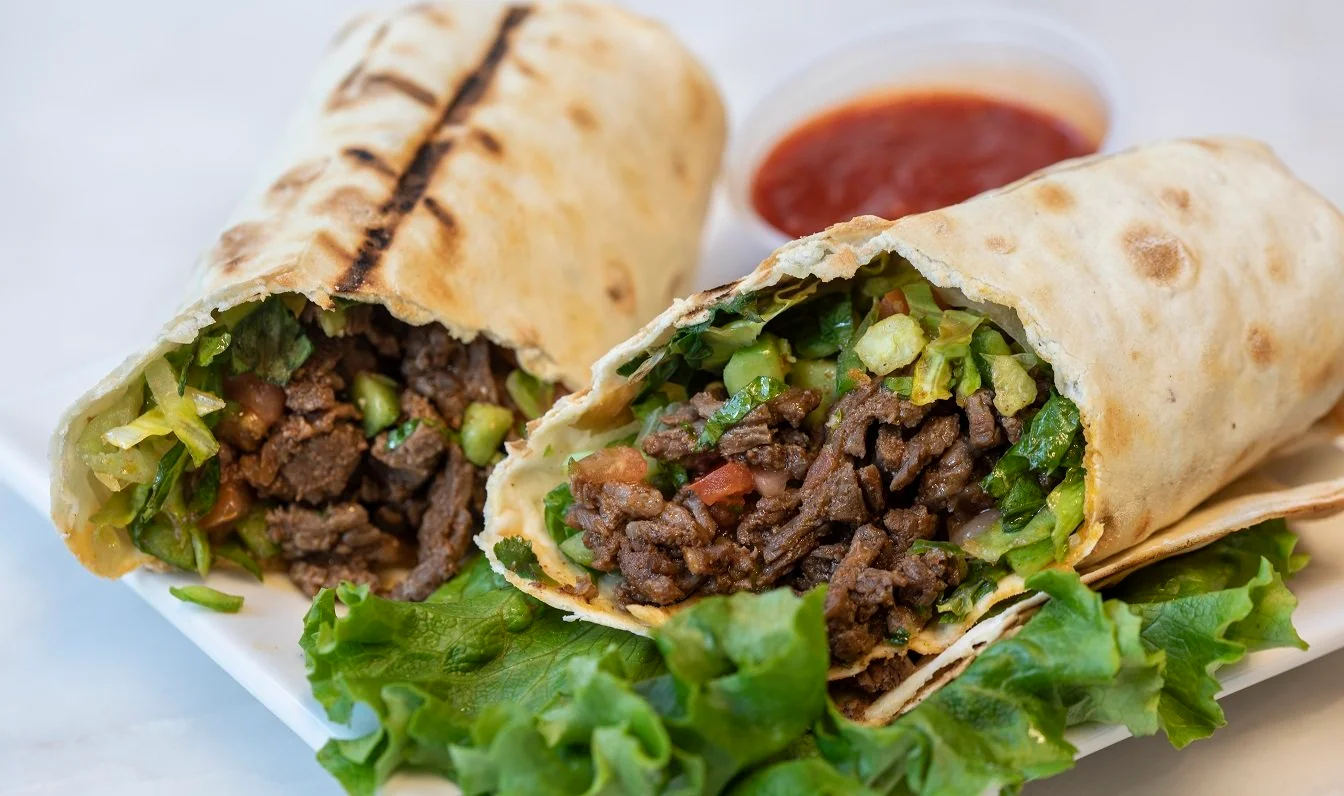 Delicious Mexican burrito filled with beef and fresh vegetables