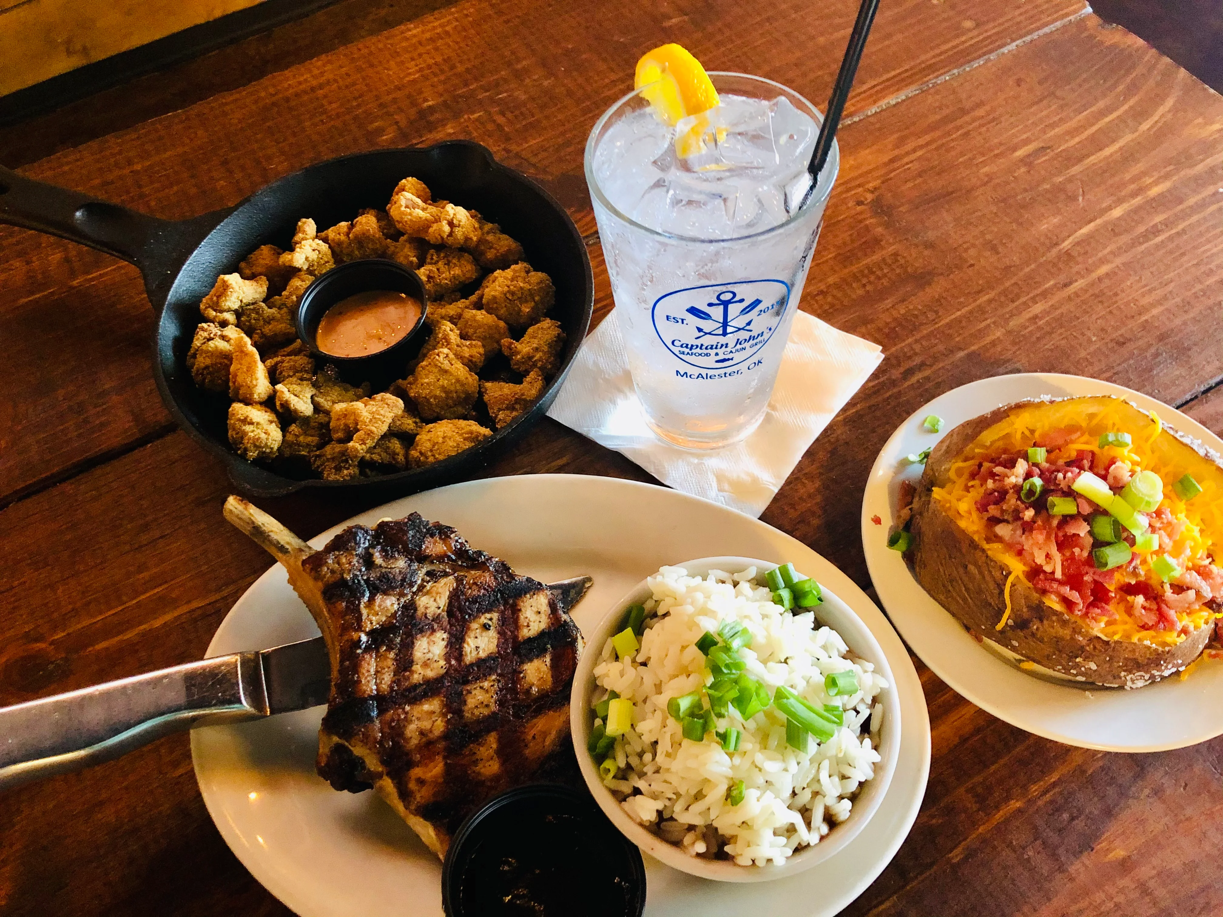 Grilled pork chop with sides in a rustic restaurant setting