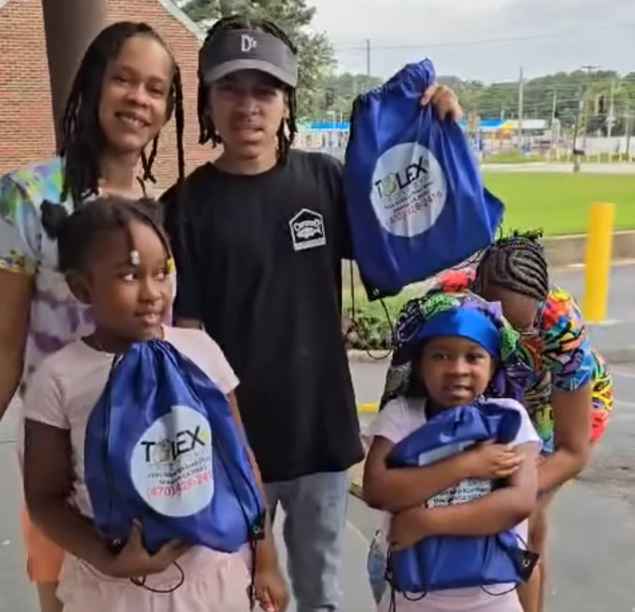 Family holding blue bags outside a community event