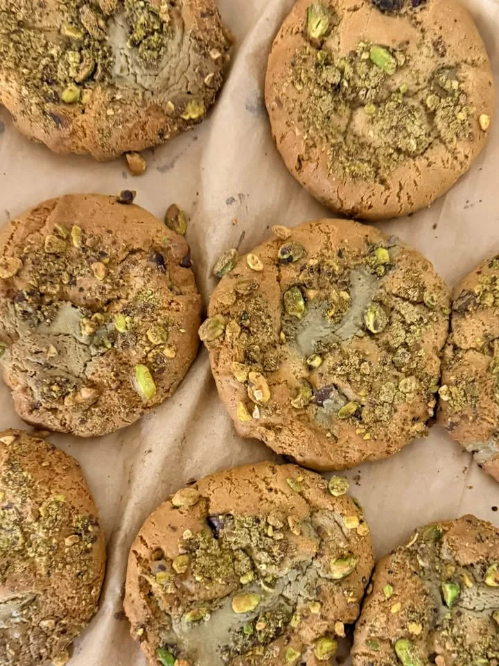 Pistachio cookies with a crunchy topping on parchment paper