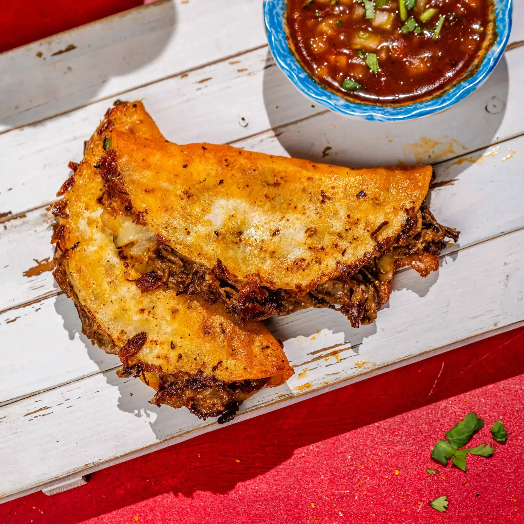 Crispy Mexican quesabirria tacos with consommé dipping sauce