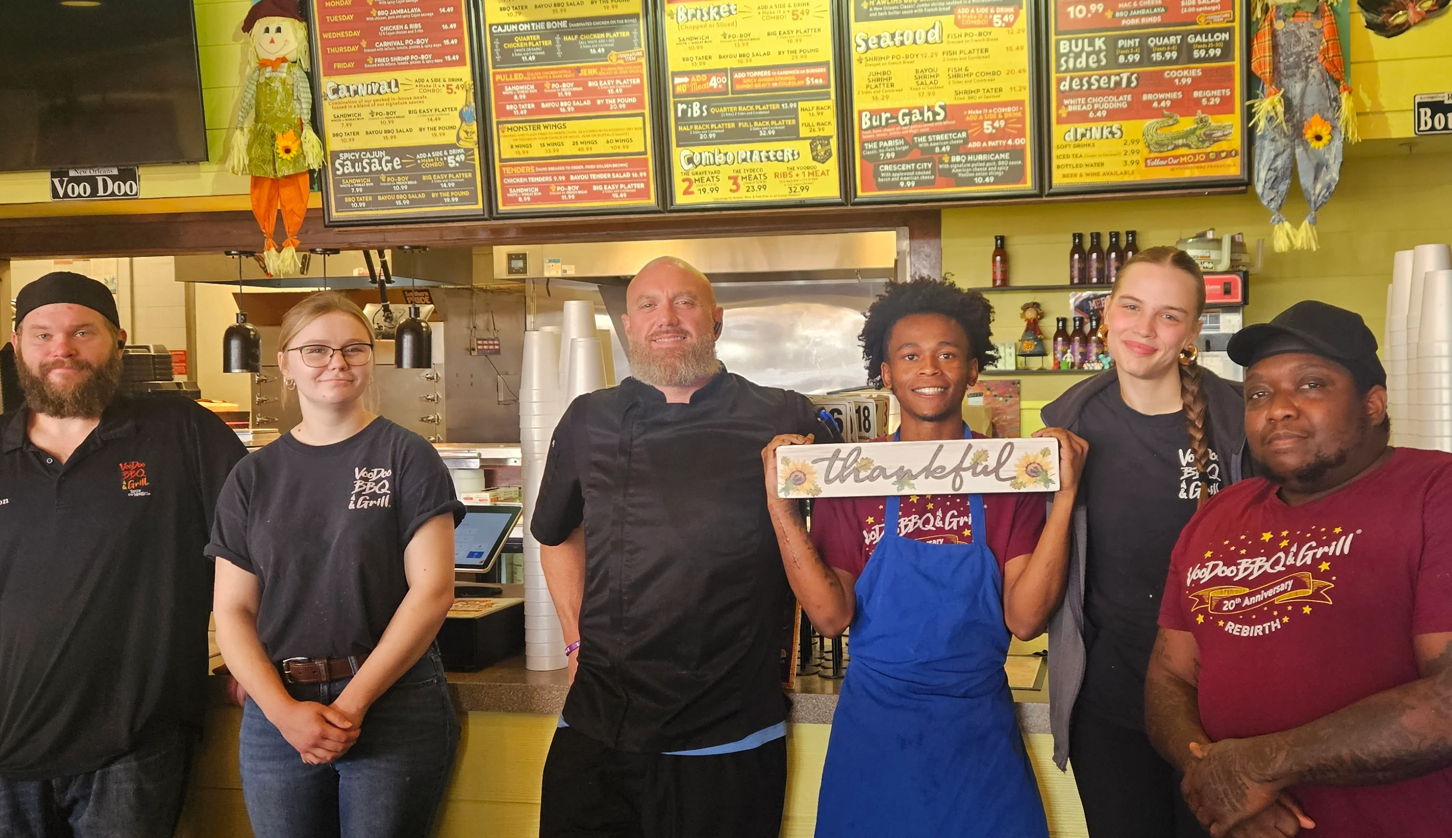 VooDoo BBQ Pensacola team smiling in the restaurant, showcasing a welcoming work environment for new job applicants.