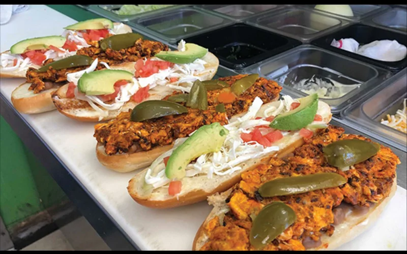 Mexican torta with spicy chicken, avocado, and jalapeños