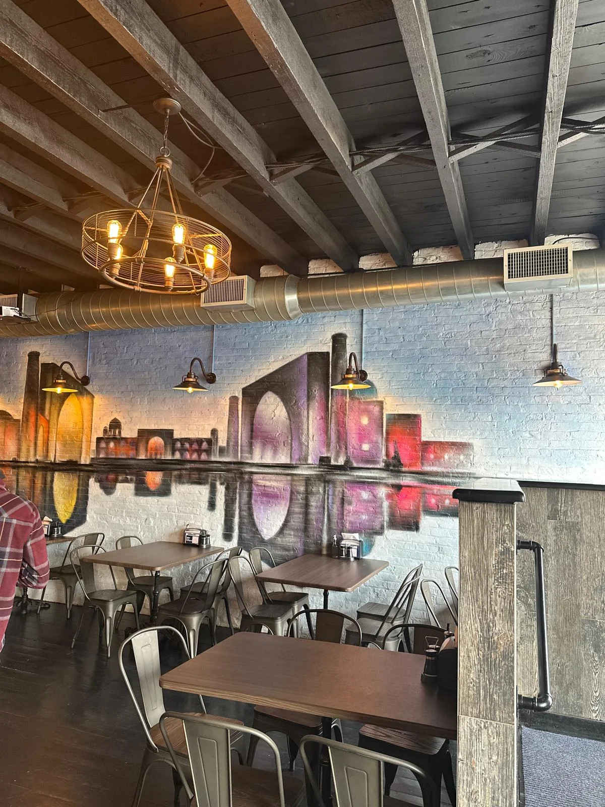 Cozy restaurant interior with artistic mural and industrial lighting