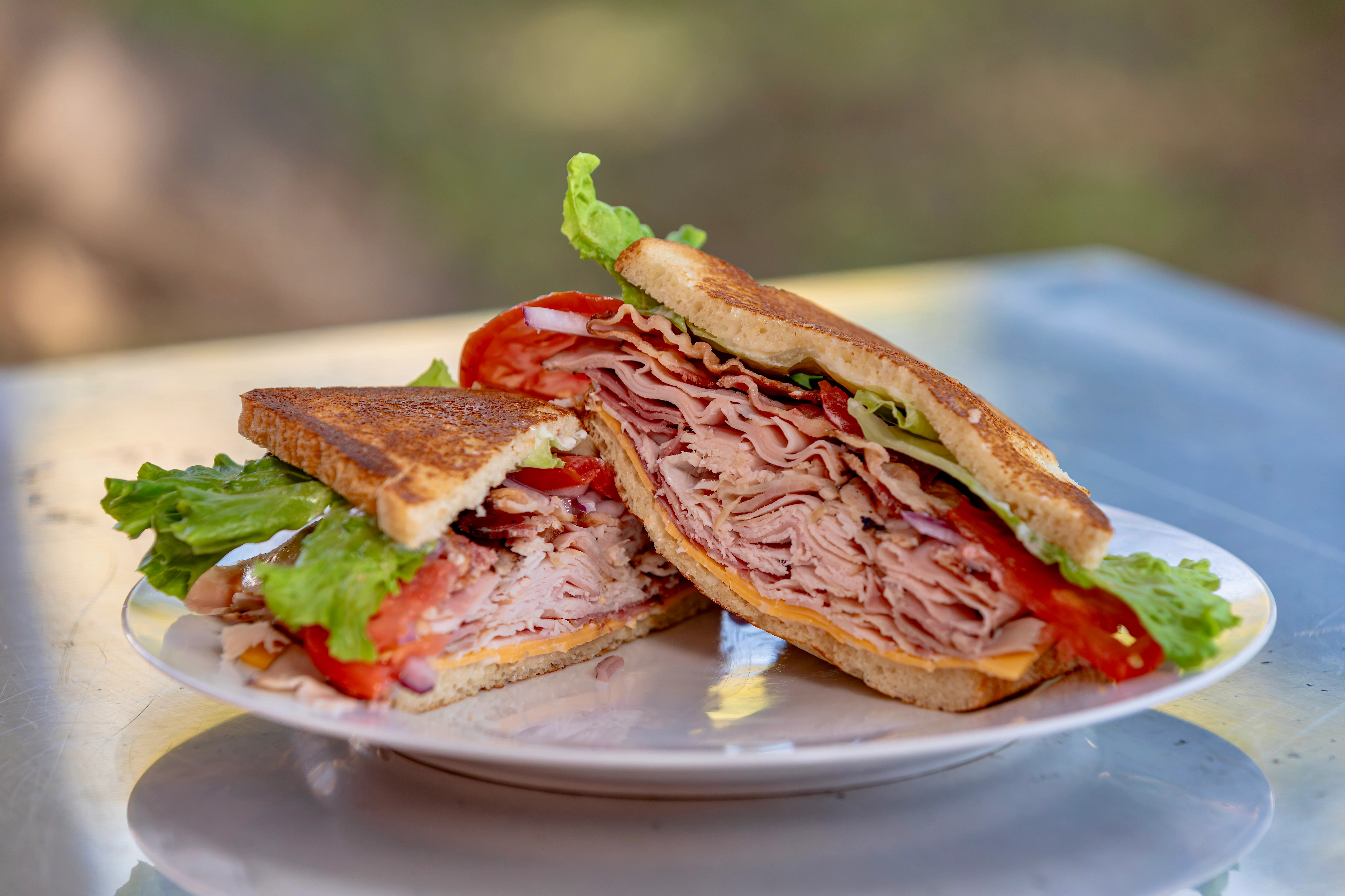 A close-up of a grilled sandwich filled with corned beef and sauerkraut, served with light paper wrapping.
