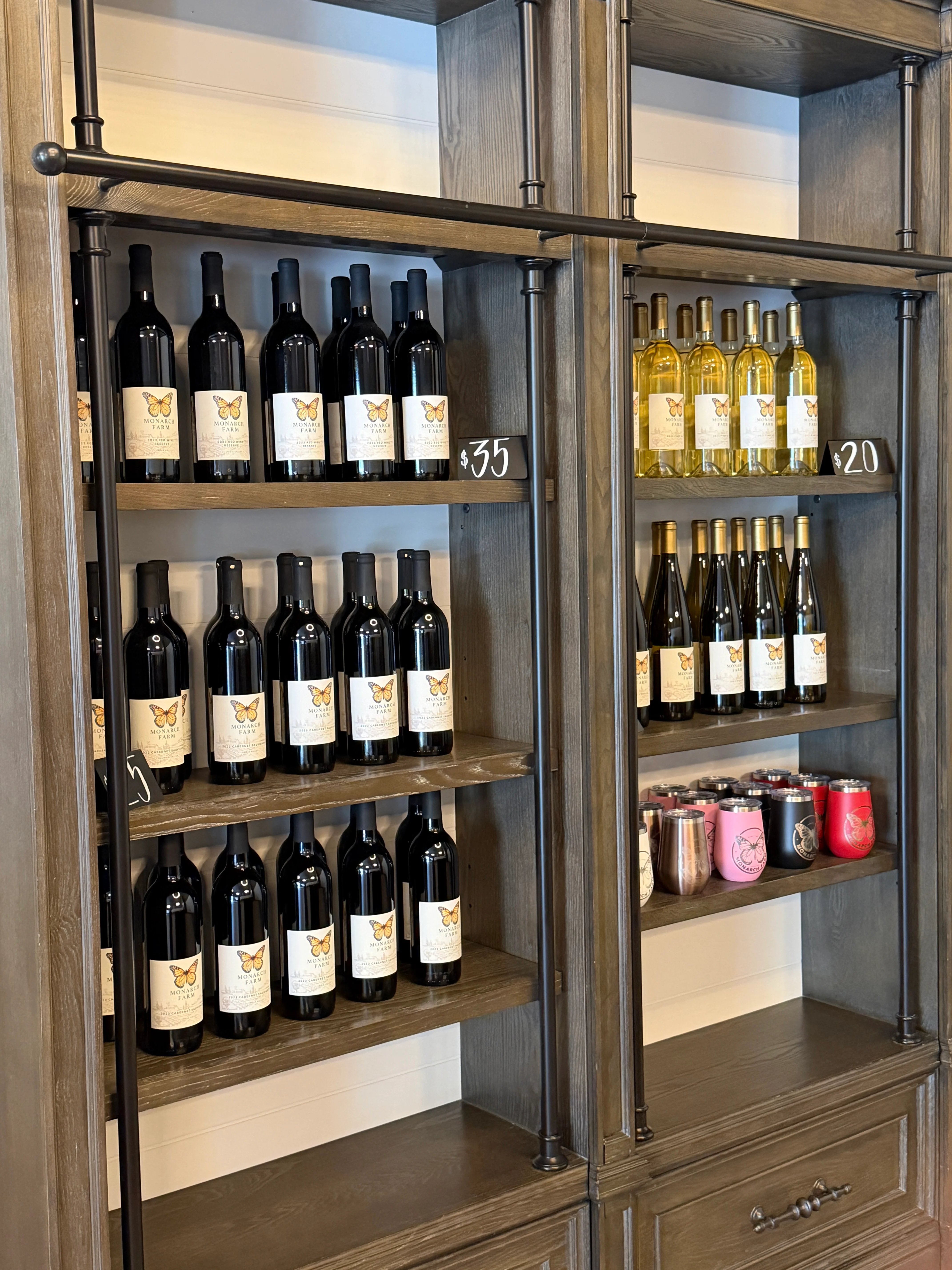 Wine bottles displayed on wooden shelves in a cozy tasting room