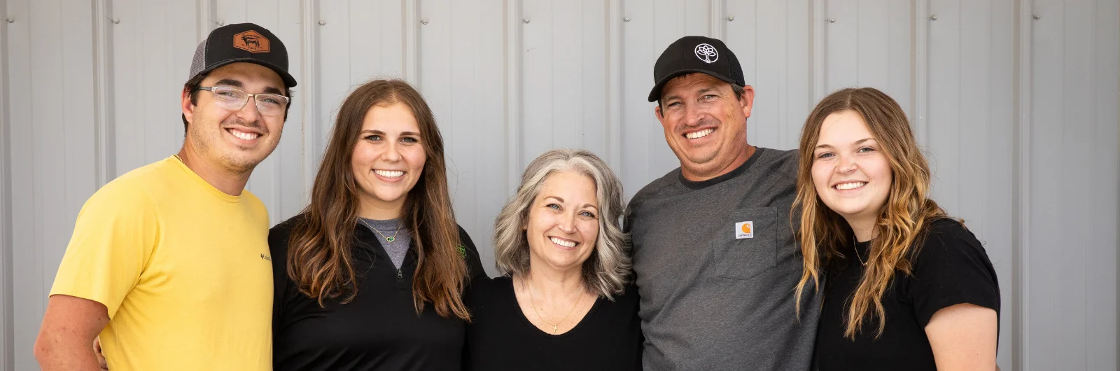 picture of five people standing in front of a barn