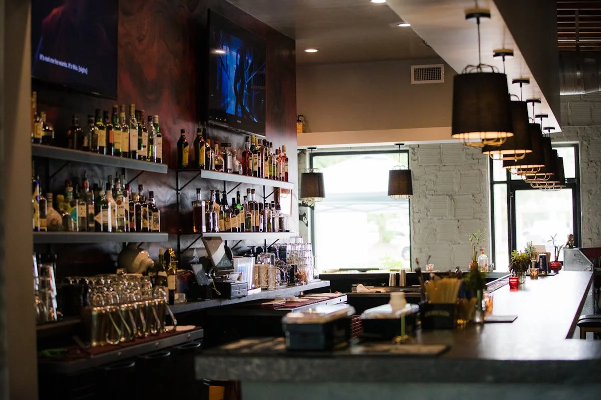 Modern bar interior with shelves of spirits and warm lighting