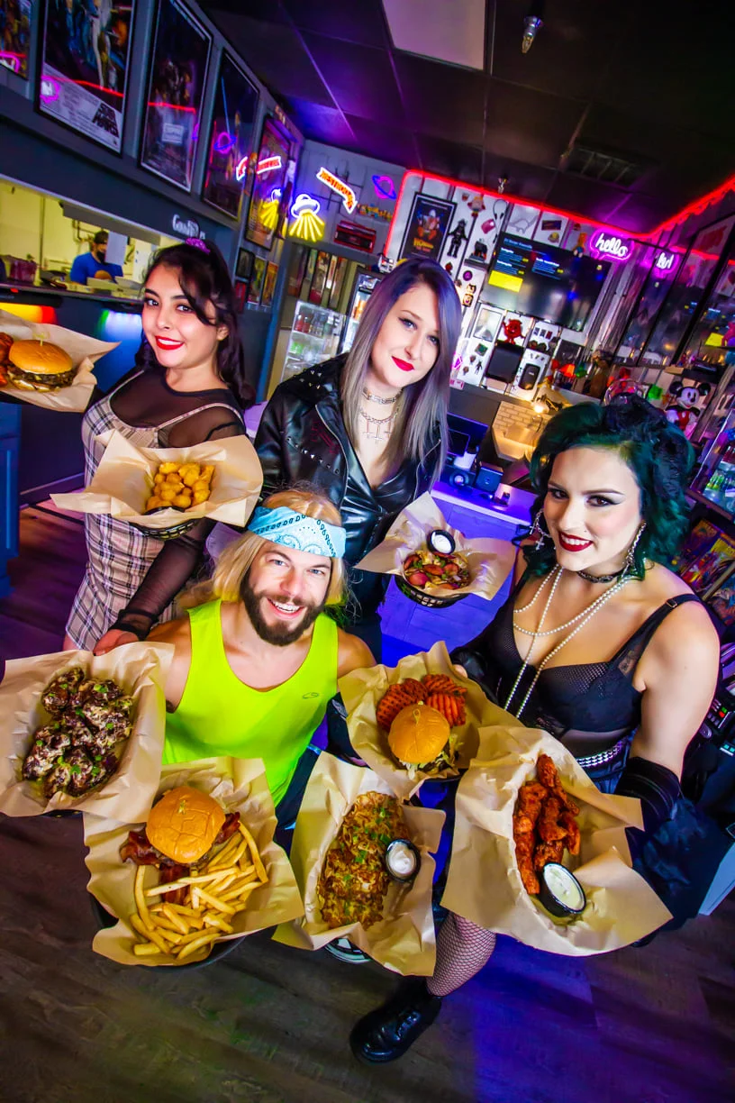Group of friends showcasing a variety of gourmet burgers and appetizers