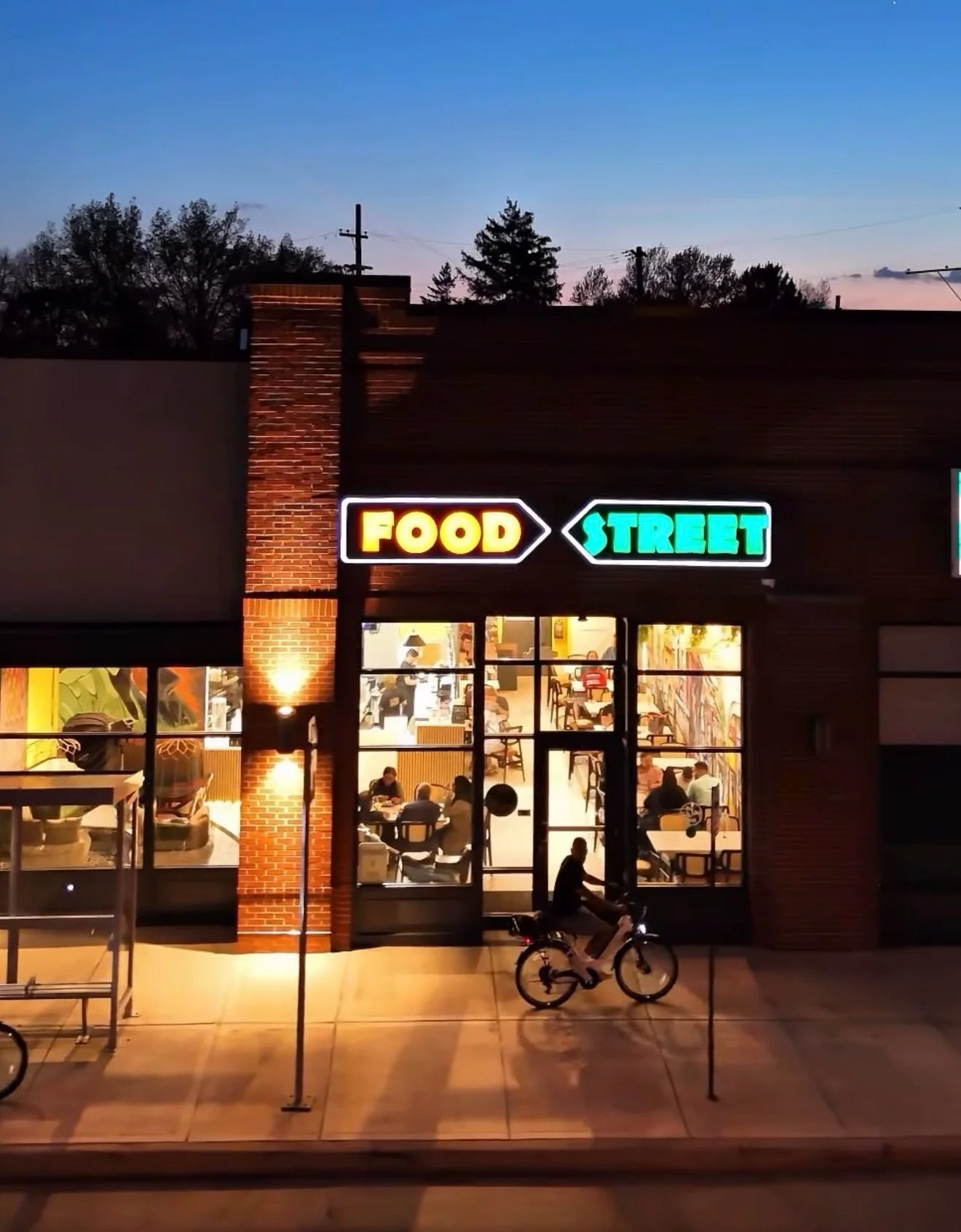 Vibrant restaurant exterior with neon signage at dusk