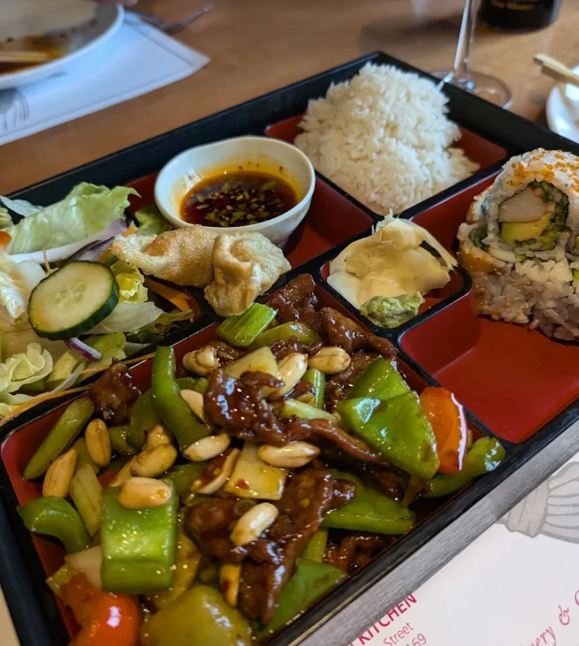 Chinese stir-fry bento box with rice and sushi