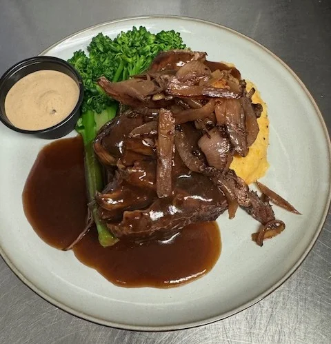 Delicious short rib entree served with garnishes on a plate.