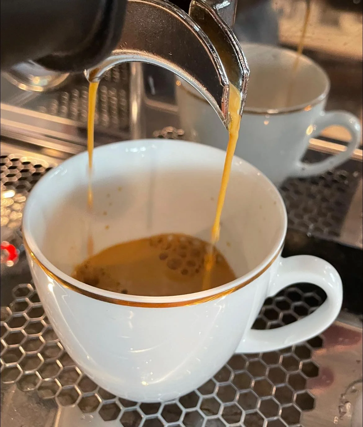 Freshly brewed espresso pouring into a cup