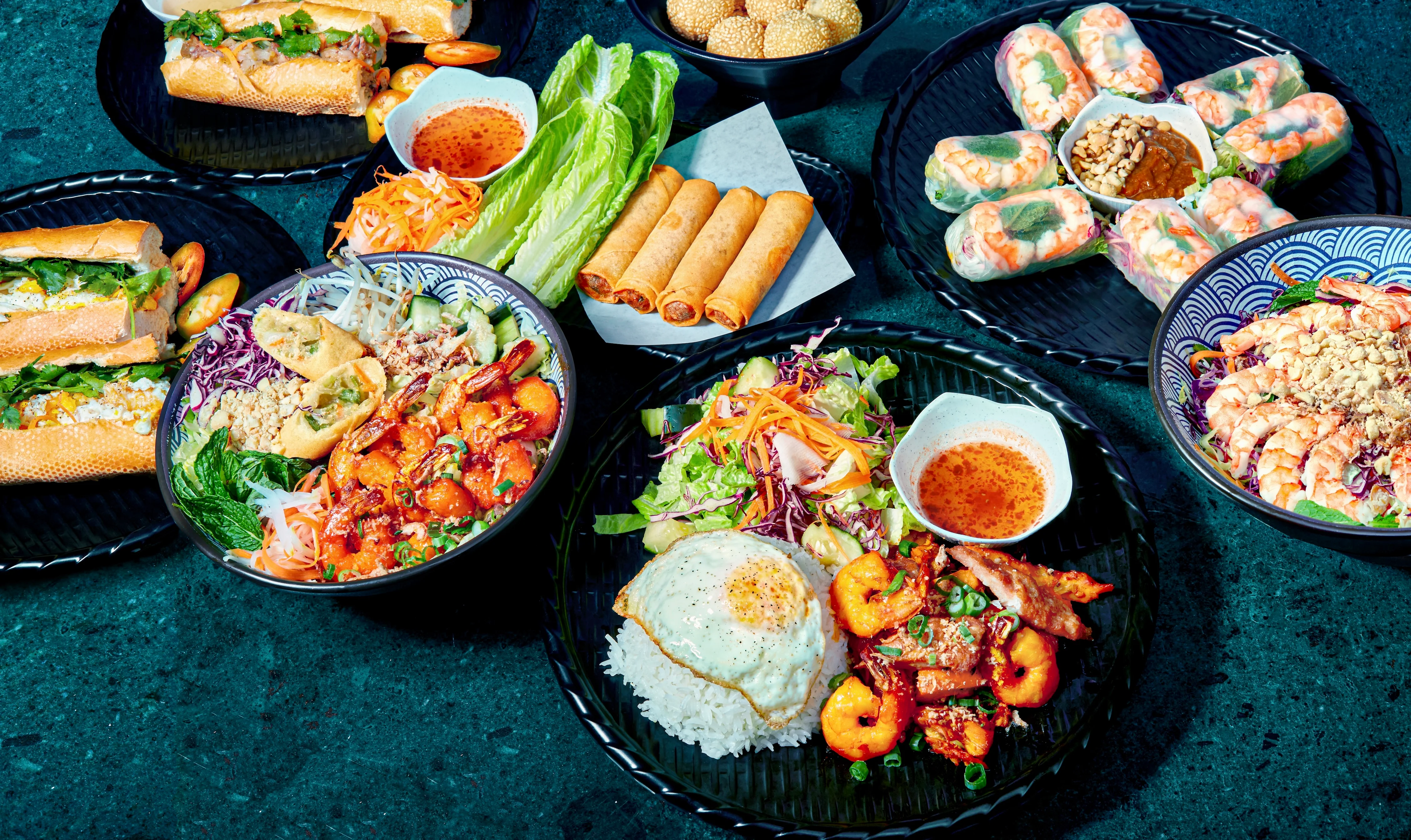 Assorted Vietnamese dishes including spring rolls and banh mi