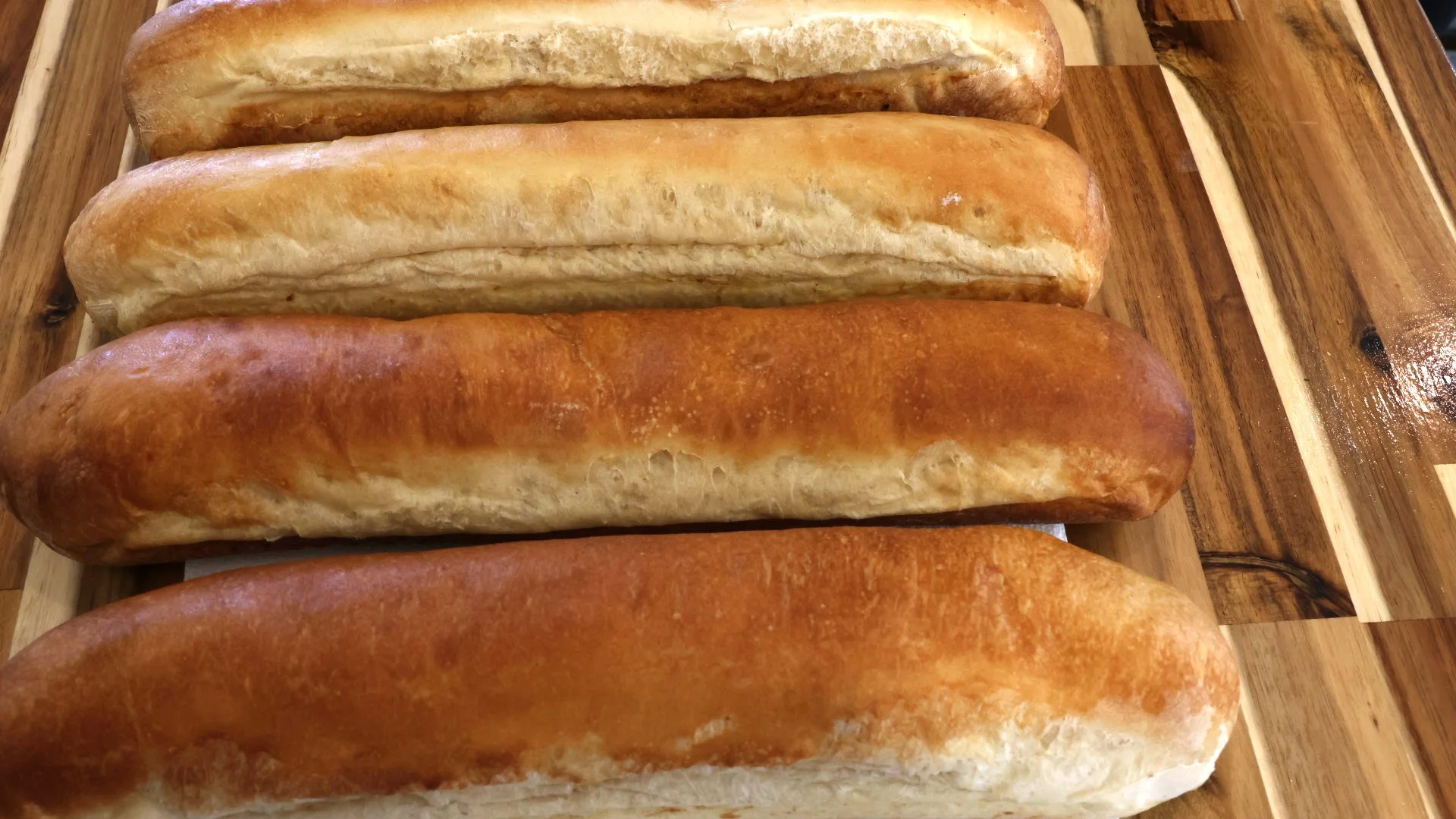 Freshly baked Italian ciabatta loaves on a wooden board