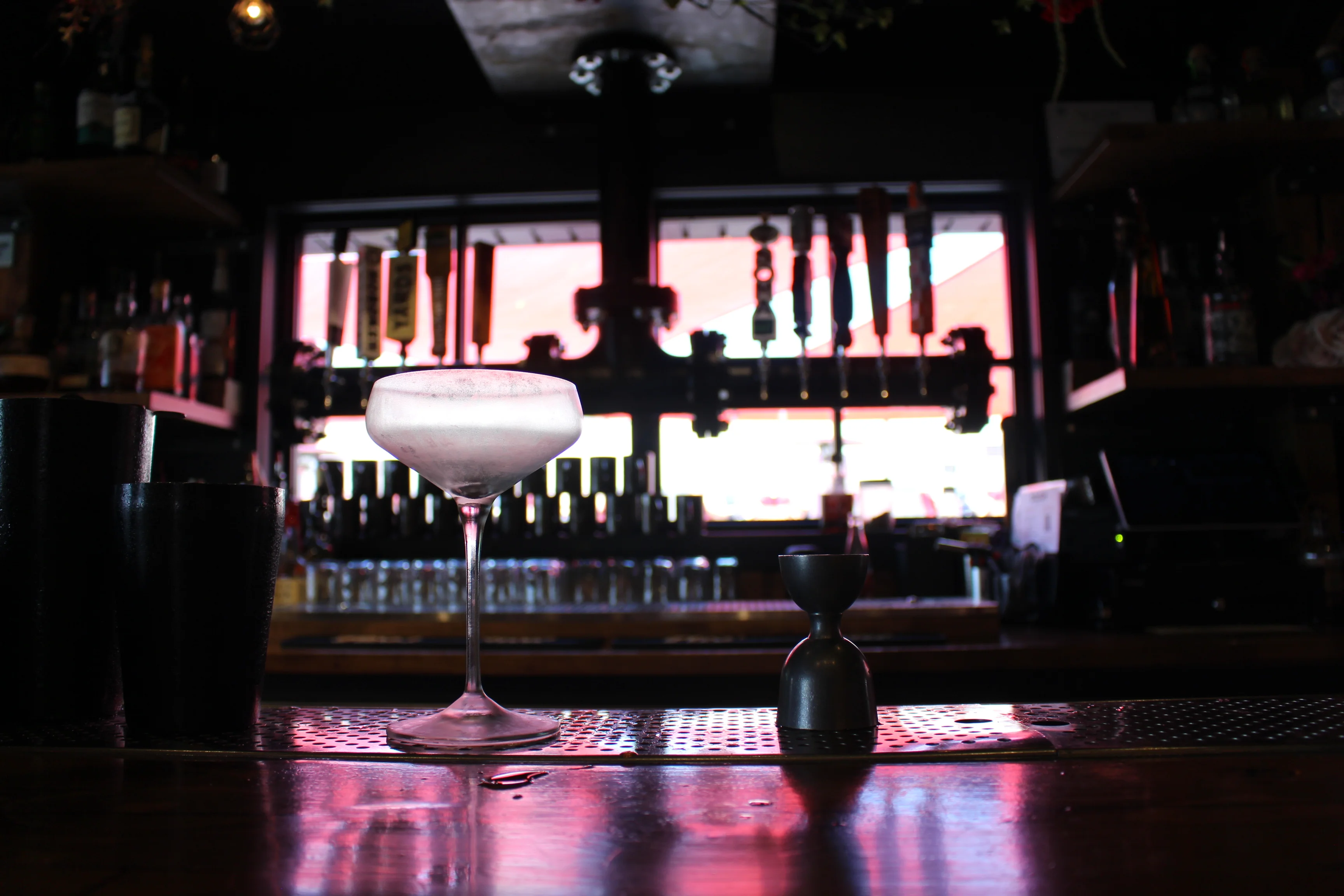 Cocktail served at a modern bar counter with vibrant lighting