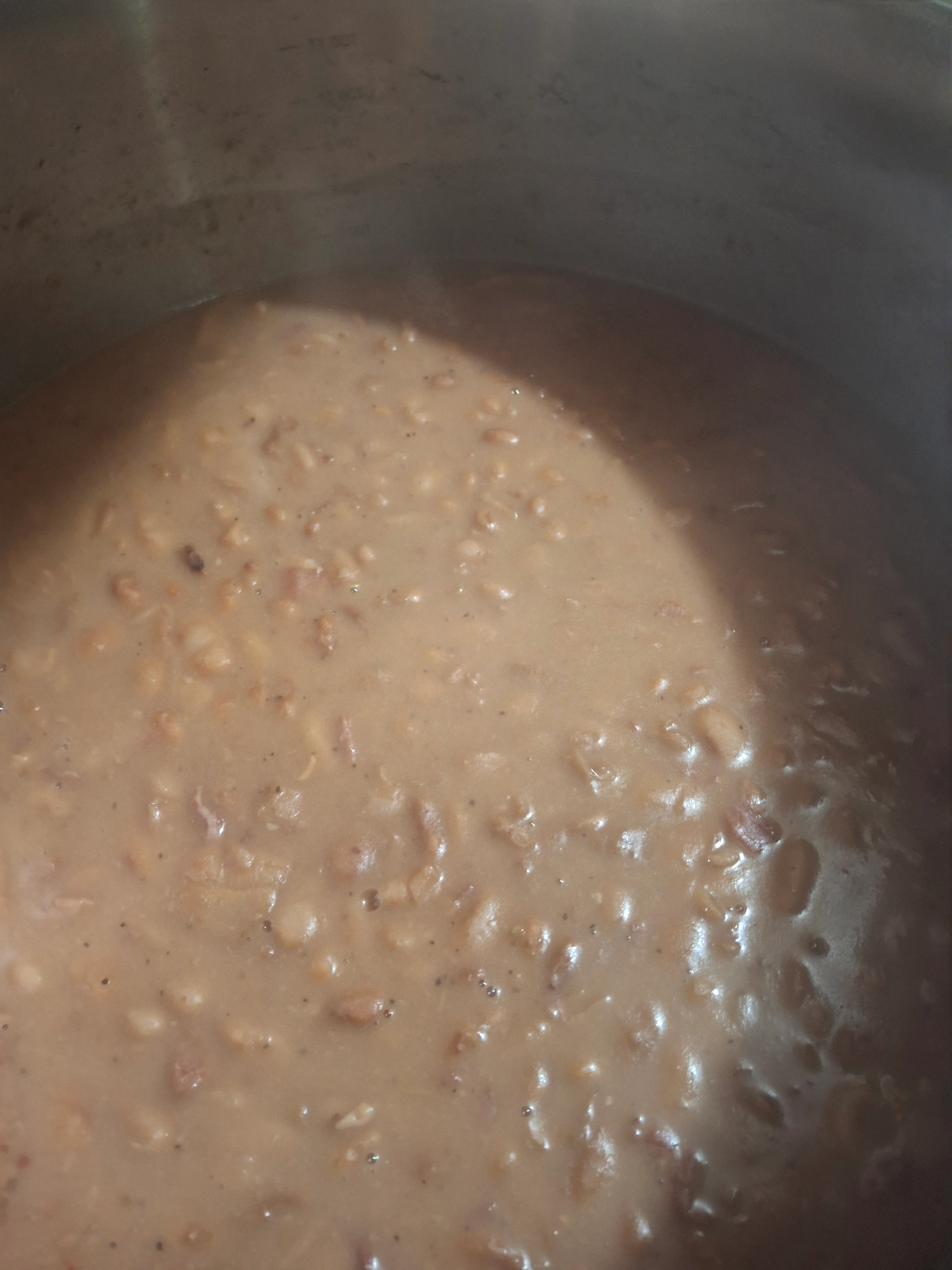 A pot of cooked beans with a creamy, thick consistency, ready for serving.