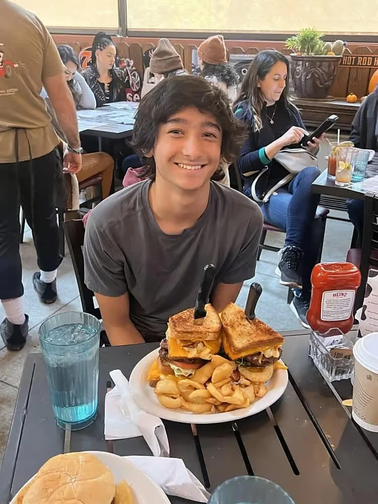 Giant cheeseburger sandwich with fries in a casual dining setting