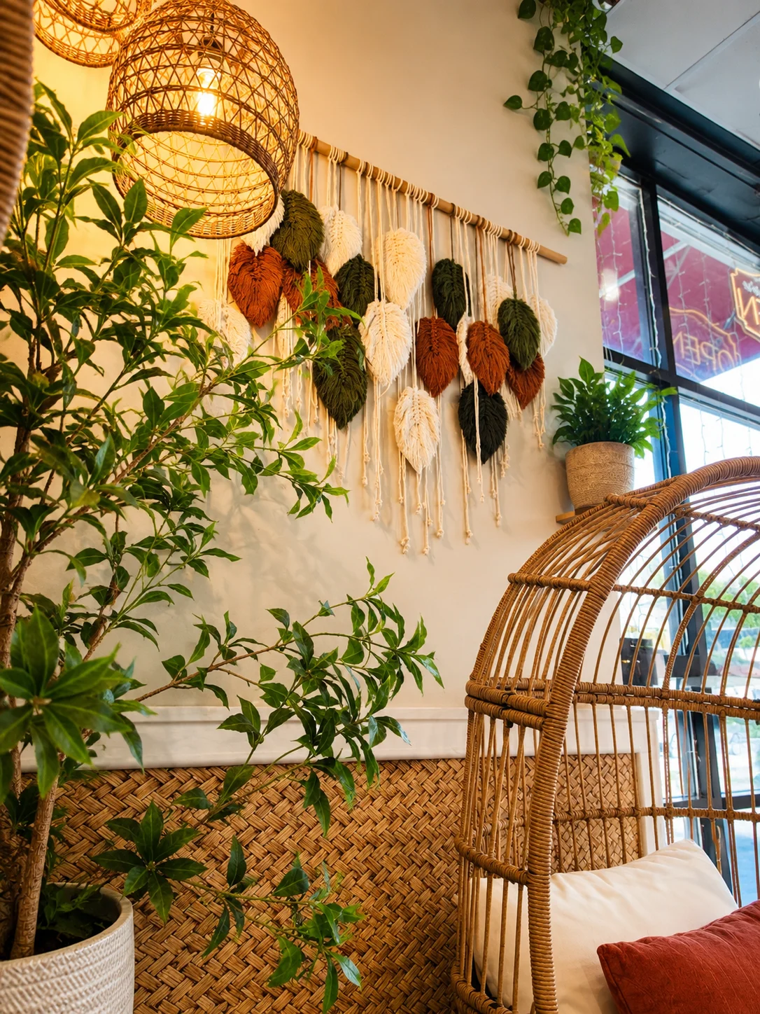 Cozy restaurant interior with woven decor and plants.