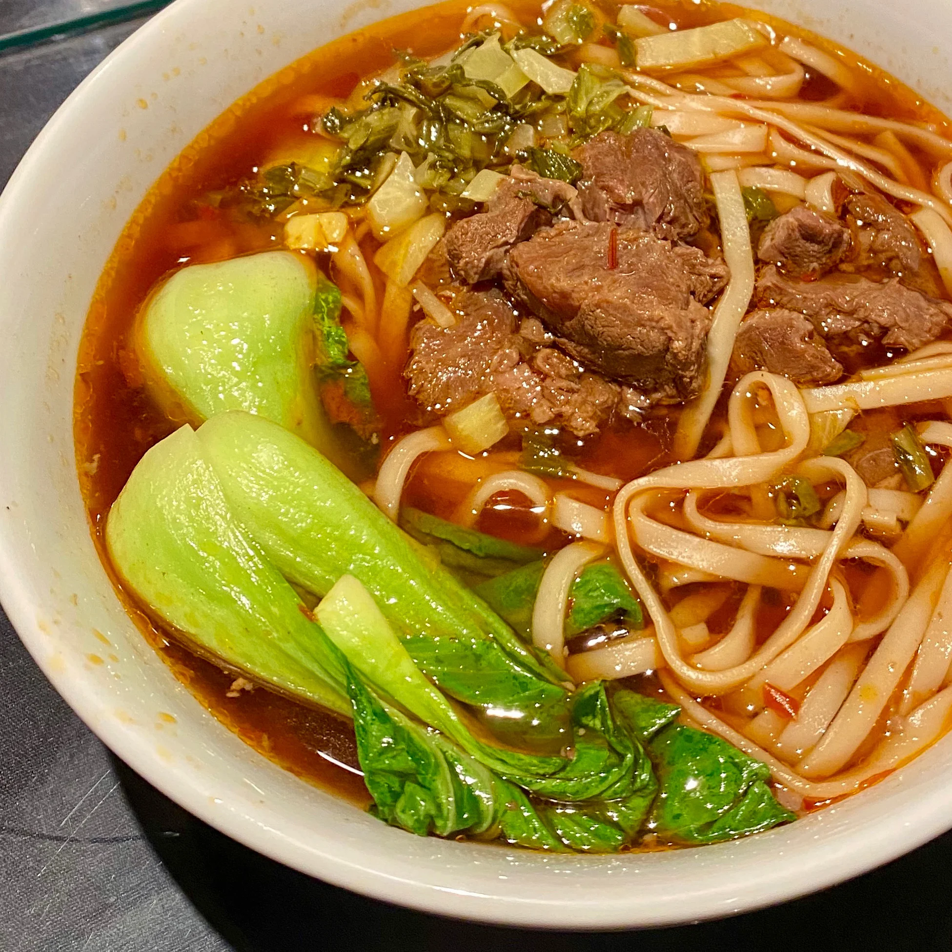 Bowl of Chinese beef noodle soup with bok choy