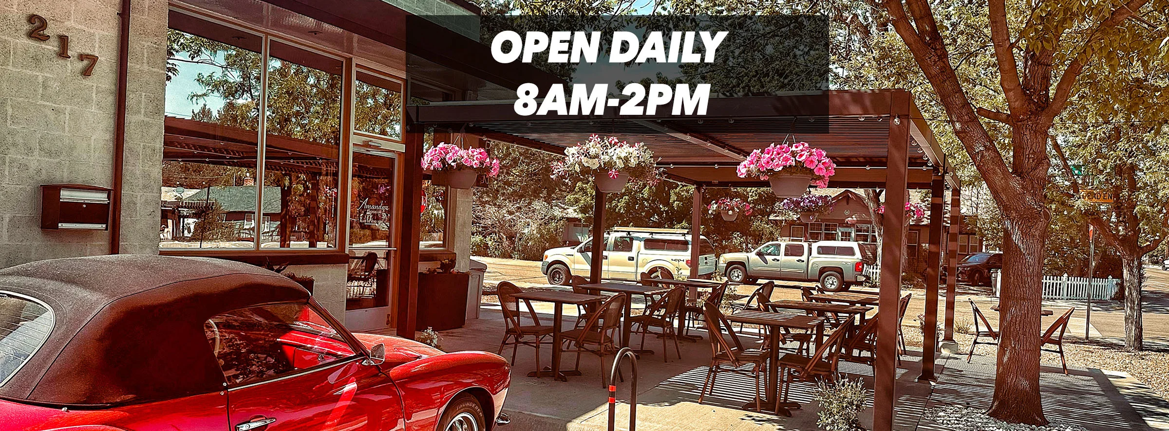 Charming outdoor dining area with flowers and a vintage car