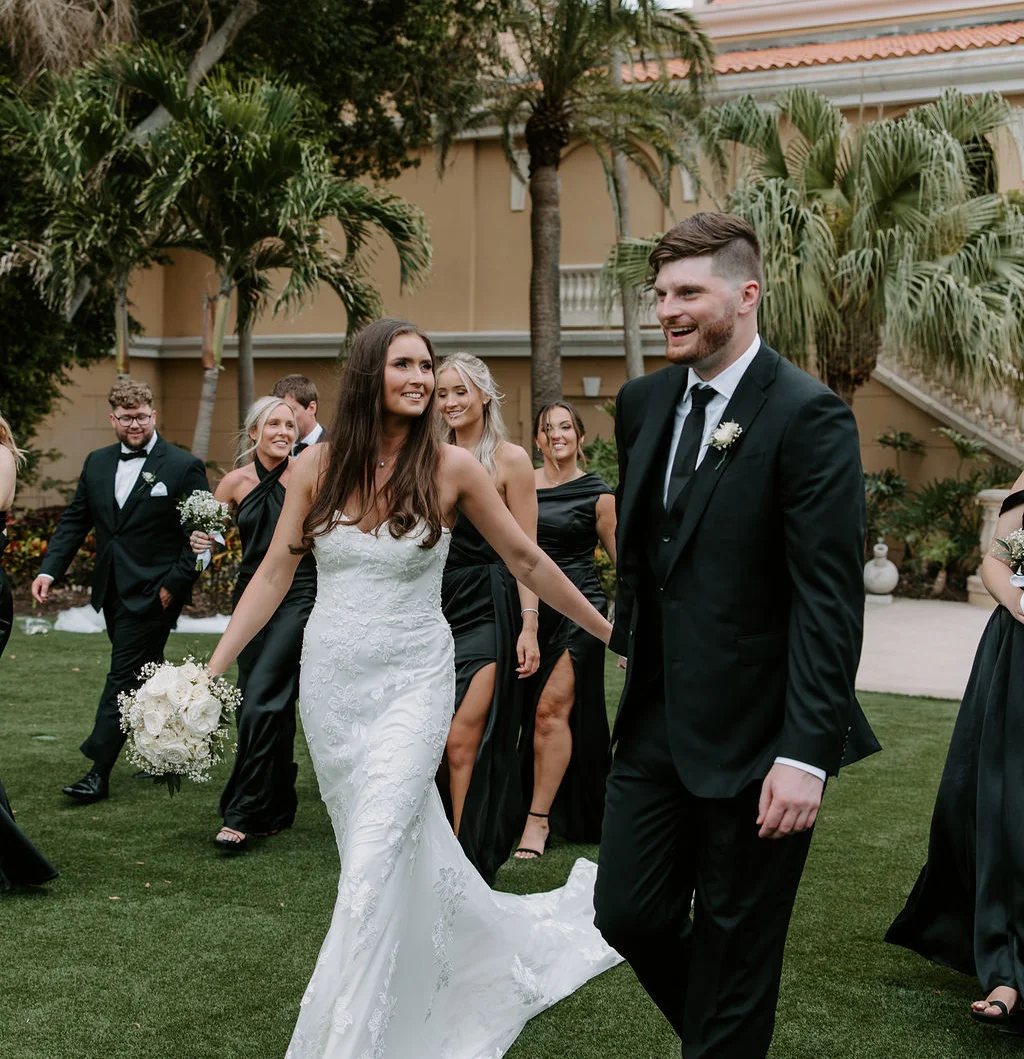 Beach wedding arch adorned with white flowers and palm trees