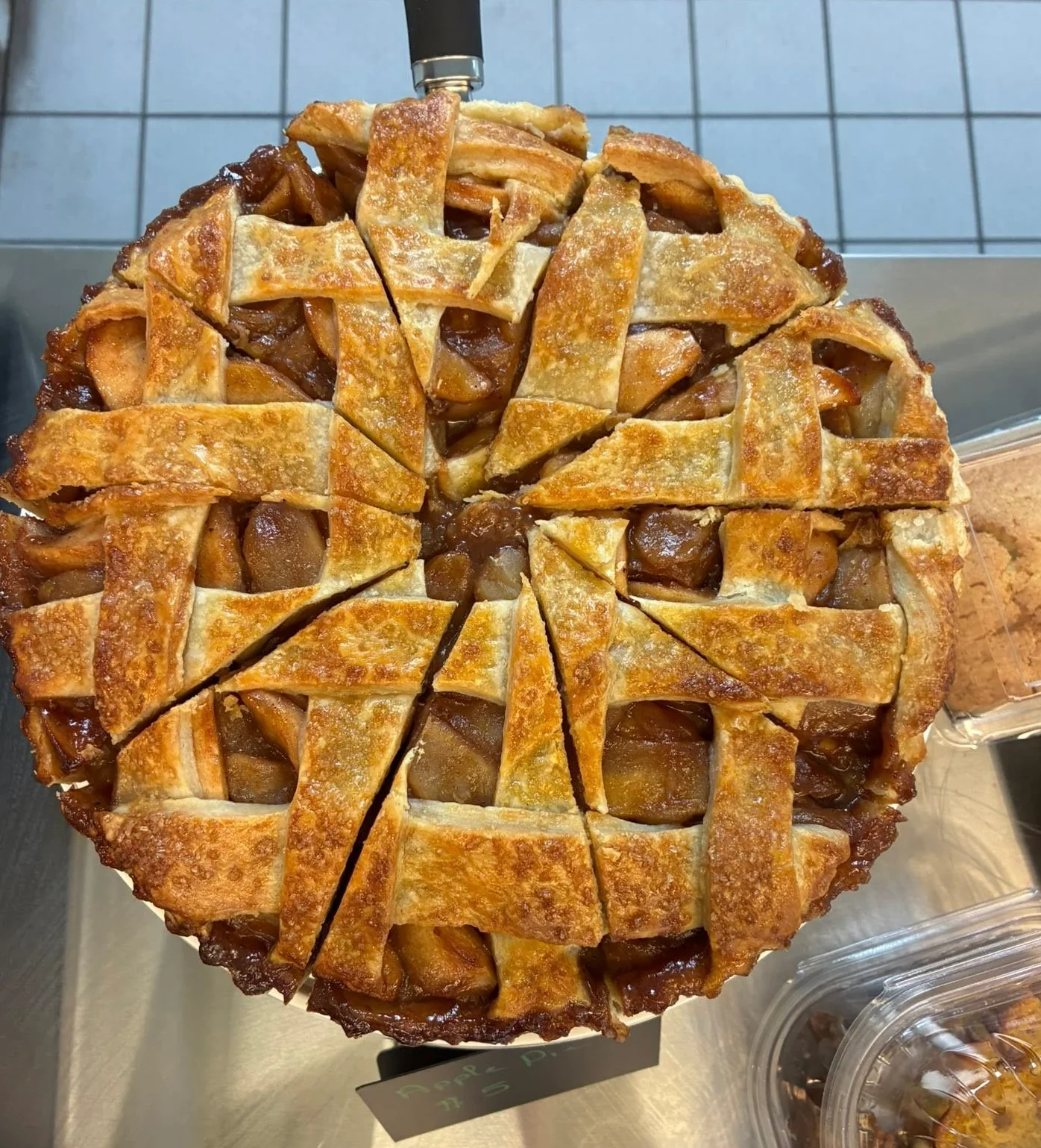 Delicious apple pie with a golden lattice crust on a serving tray.
