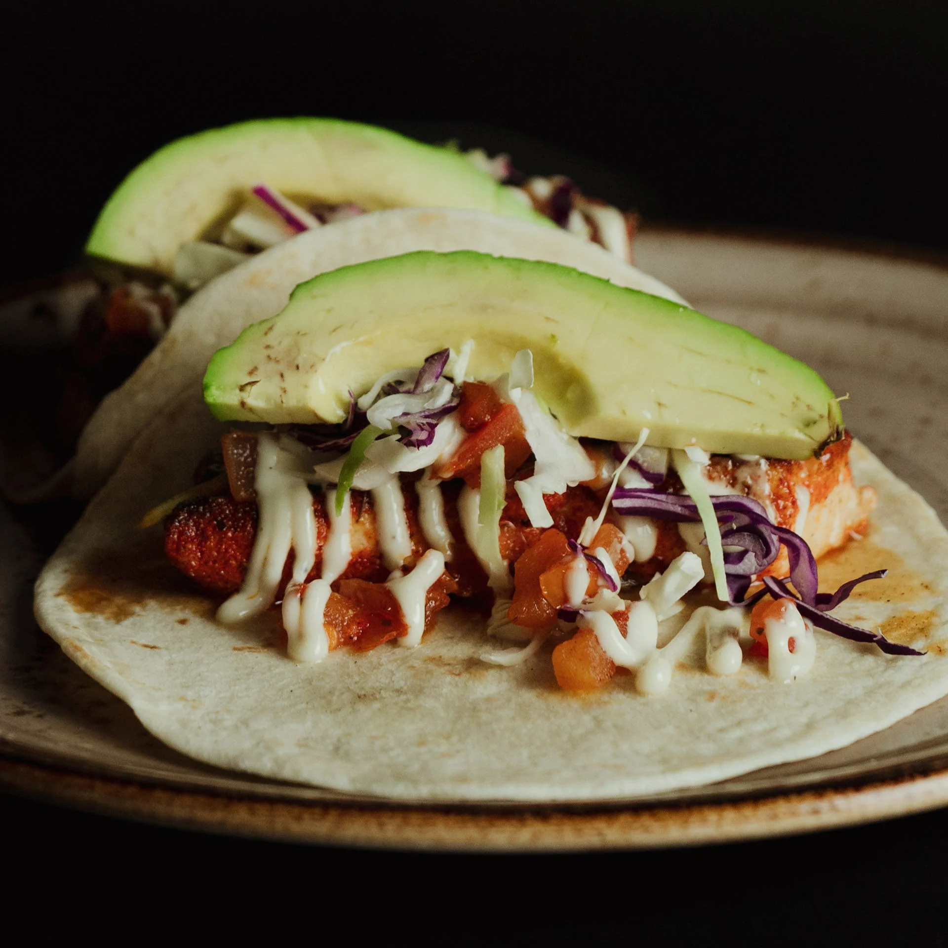Delicious fish tacos topped with avocado and cabbage