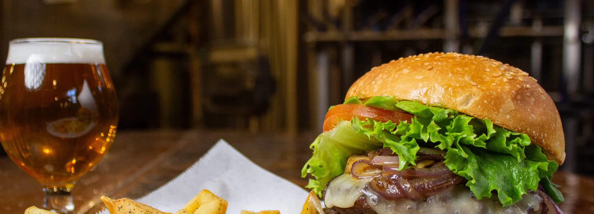 Juicy cheeseburger with fries in a brewery setting