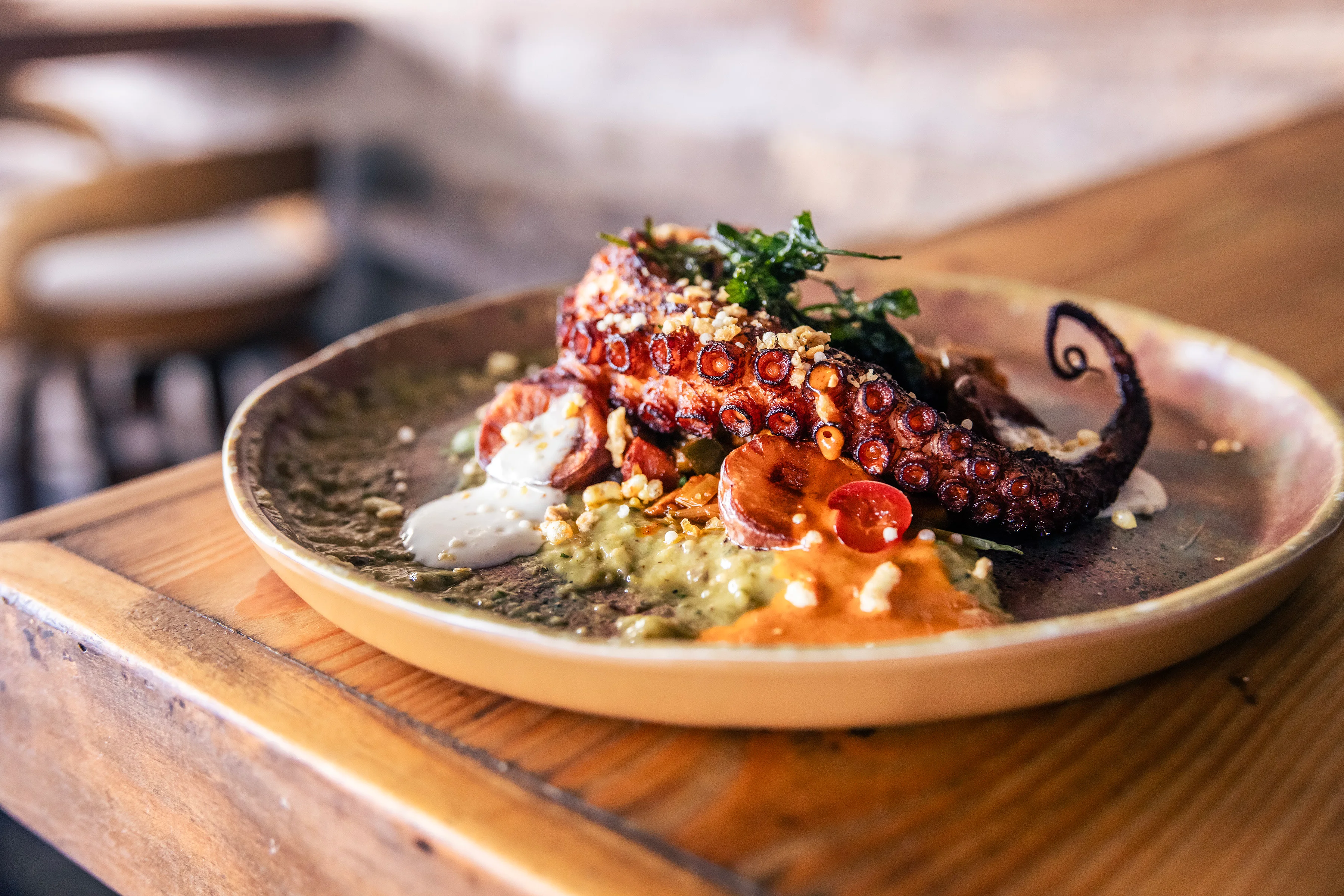 Grilled octopus served on a vibrant plate