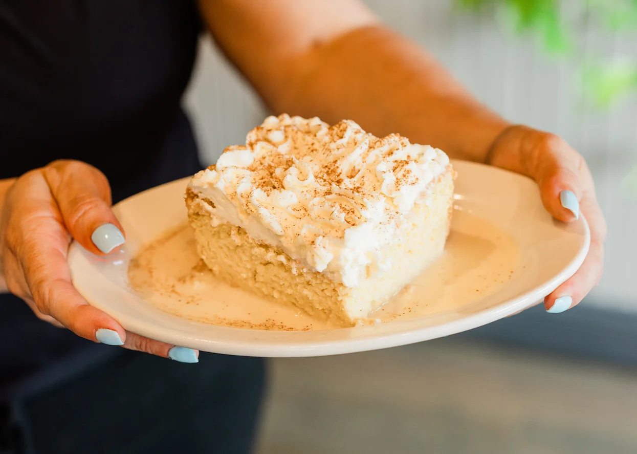 Delicious tres leches cake topped with whipped cream