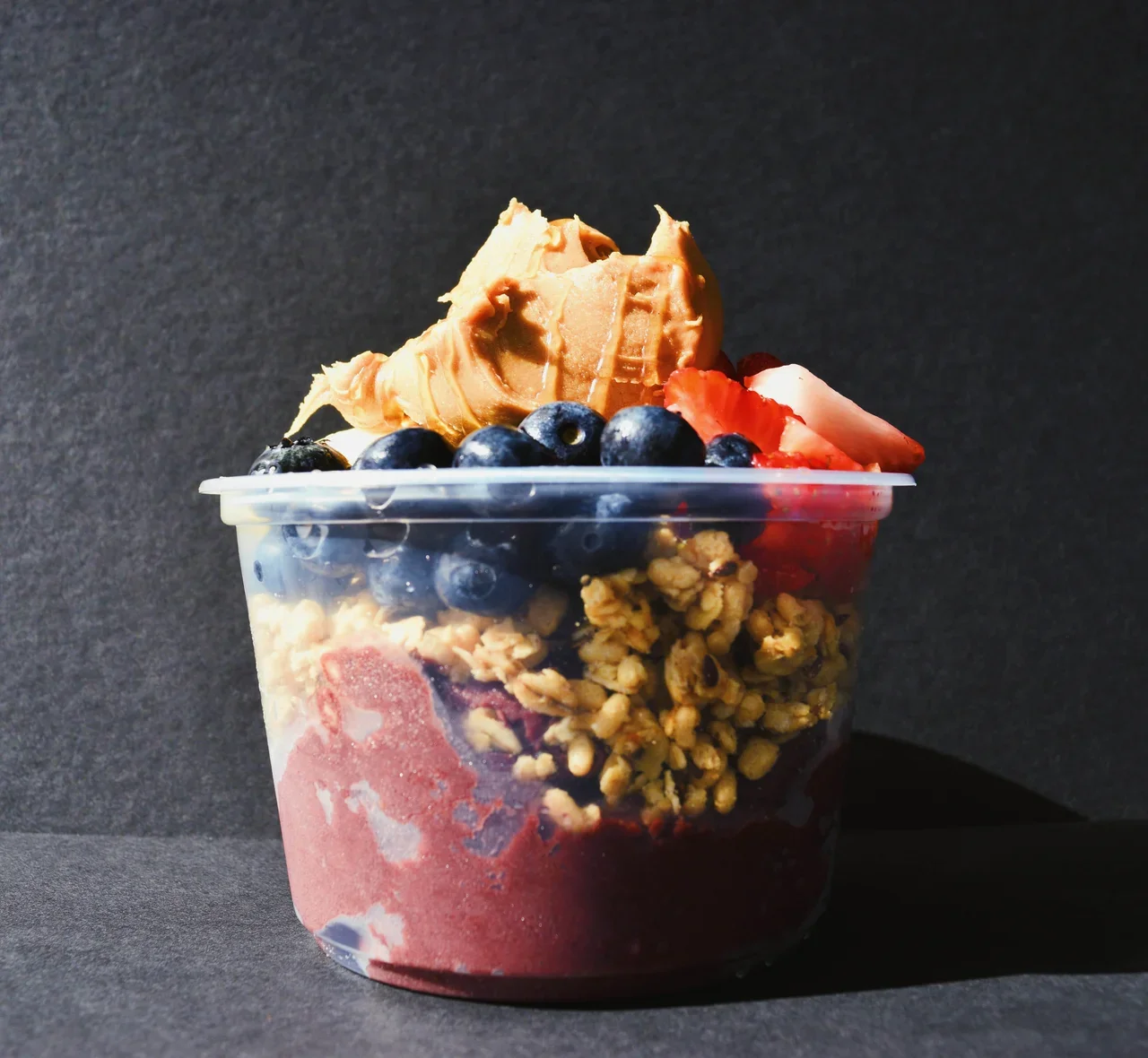 Acai bowl topped with peanut butter and fresh berries