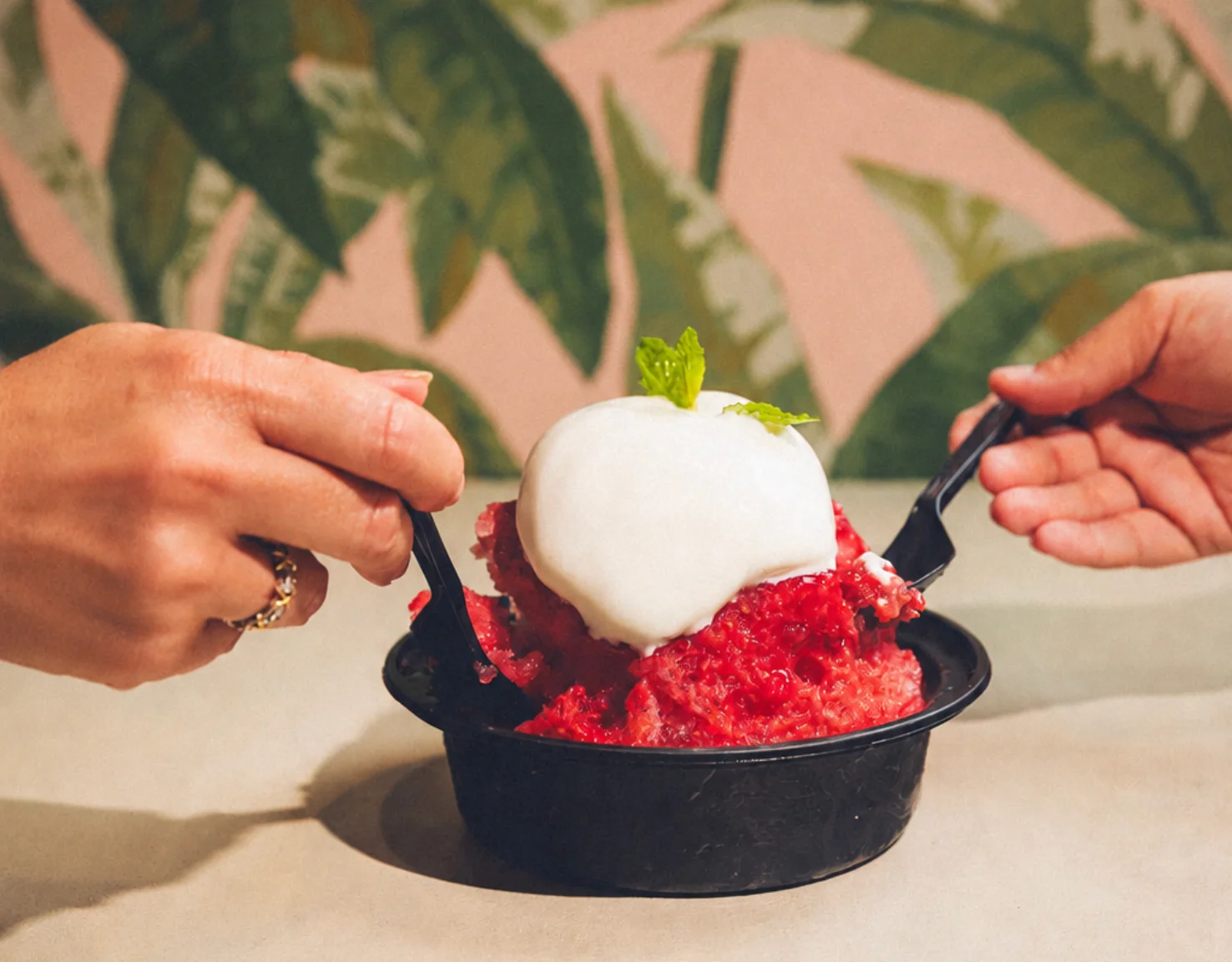 Three bowls of hand-shaved Hawaiian shave ice with mango, coconut cream and strawberry toppings.