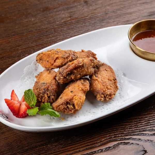 Crispy fried chicken wings served with dipping sauce