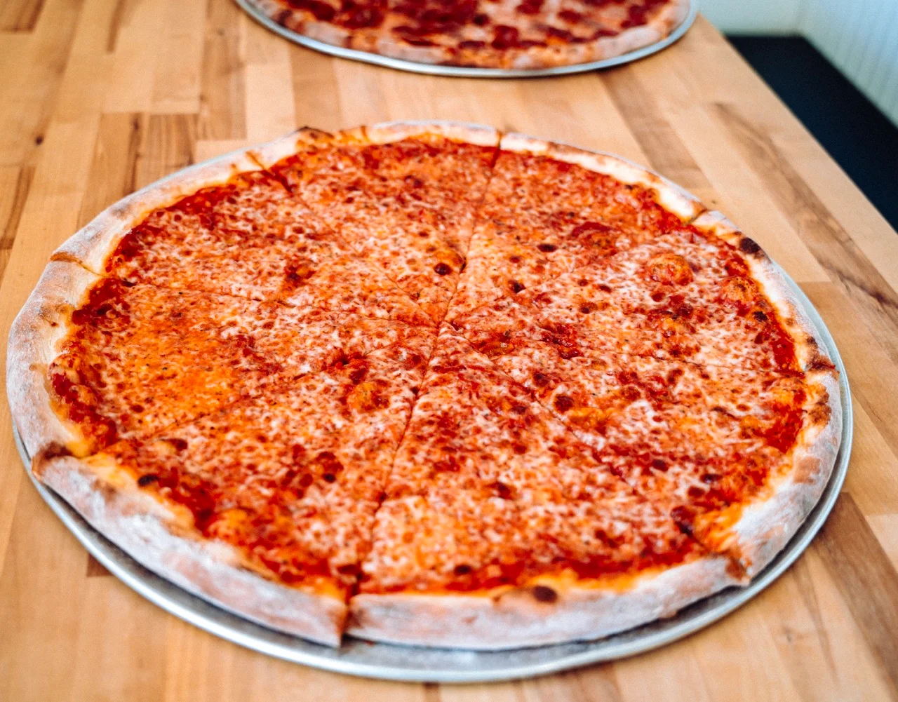 Classic cheese pizza served on a wooden table