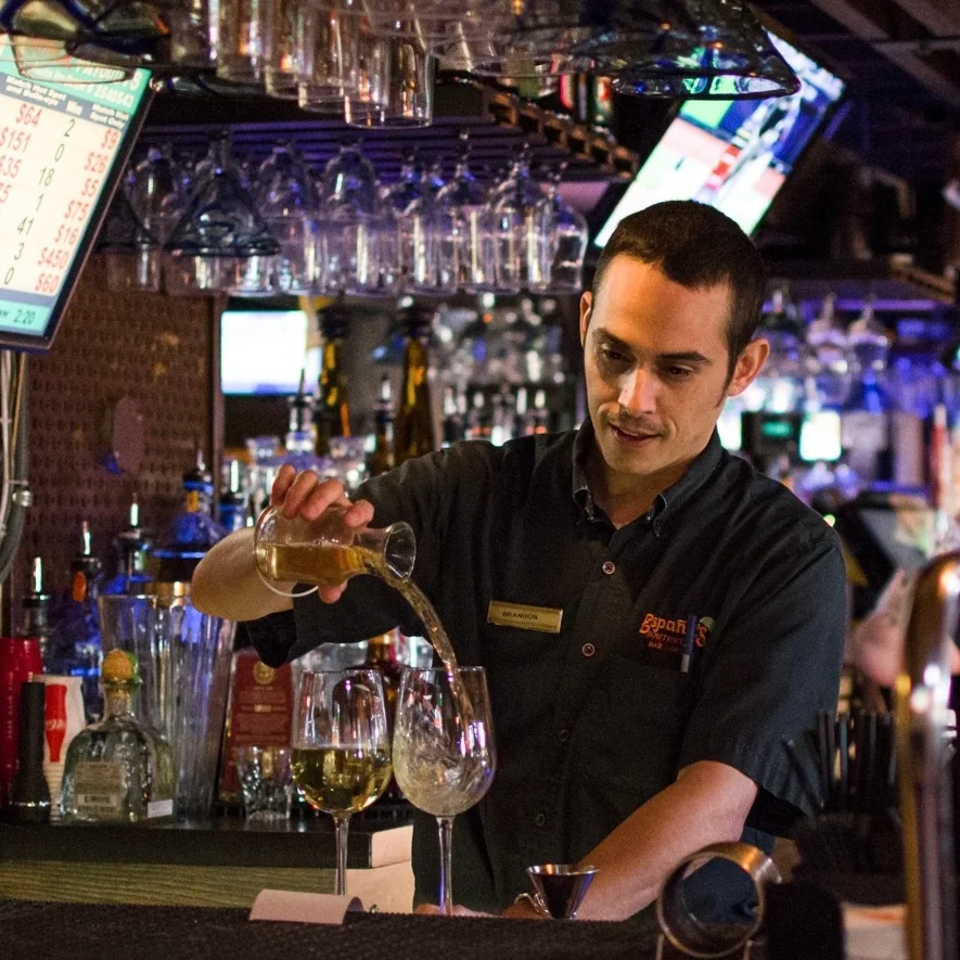 A bartender pouring an alcoholic beverage