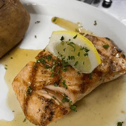 Grilled salmon fillet with lemon garnish