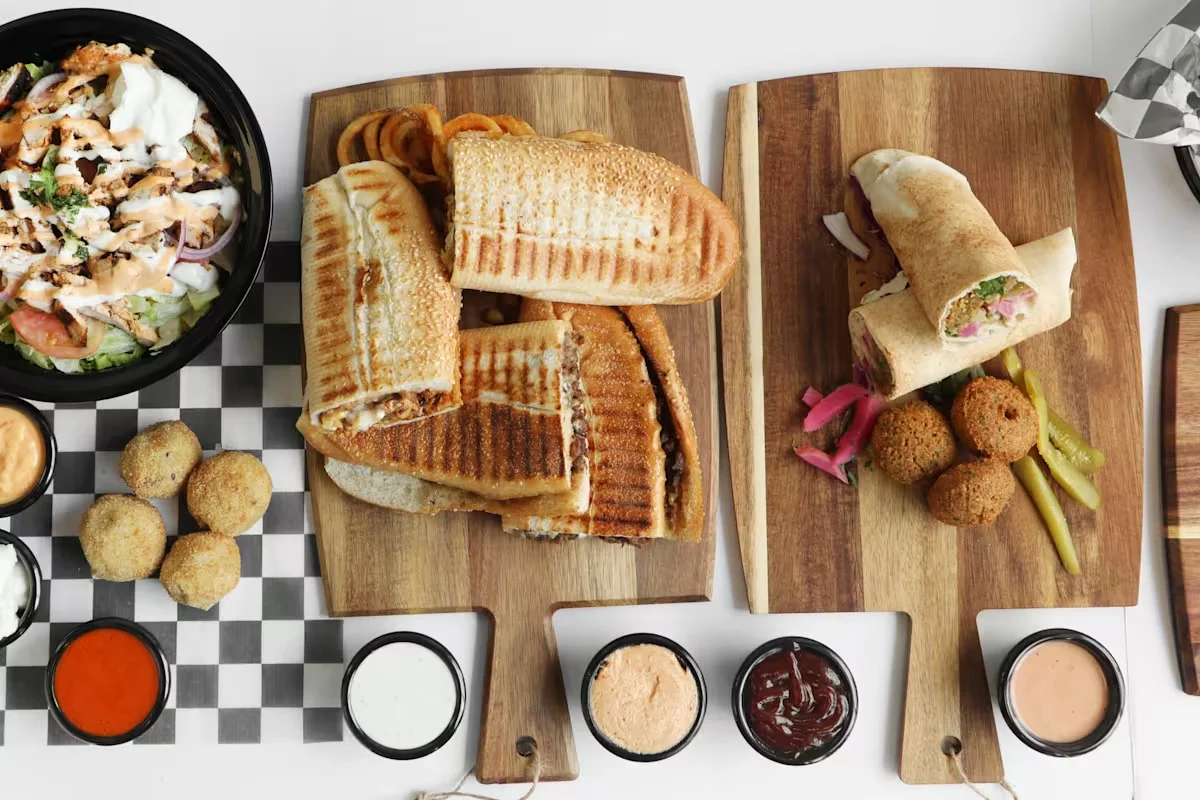 A variety of delicious dishes including sandwiches, salad, and sauces.