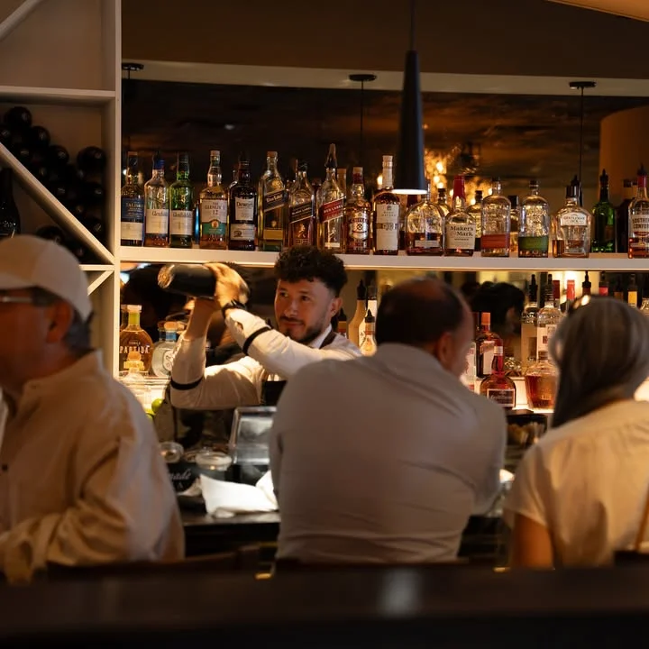 Bartender crafting cocktails at a stylish bar