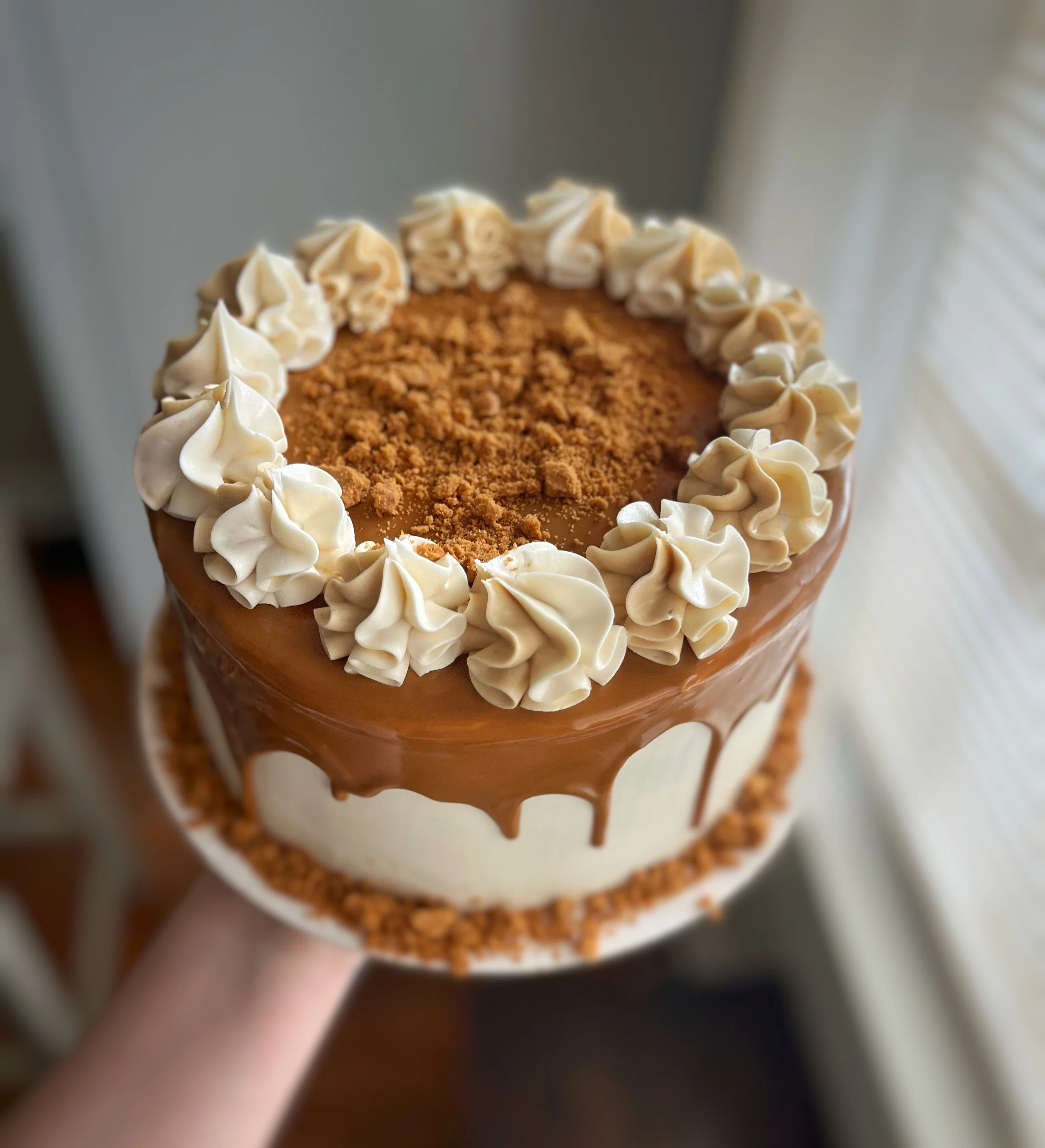 Decadent caramel cake with whipped cream and cookie crumble topping