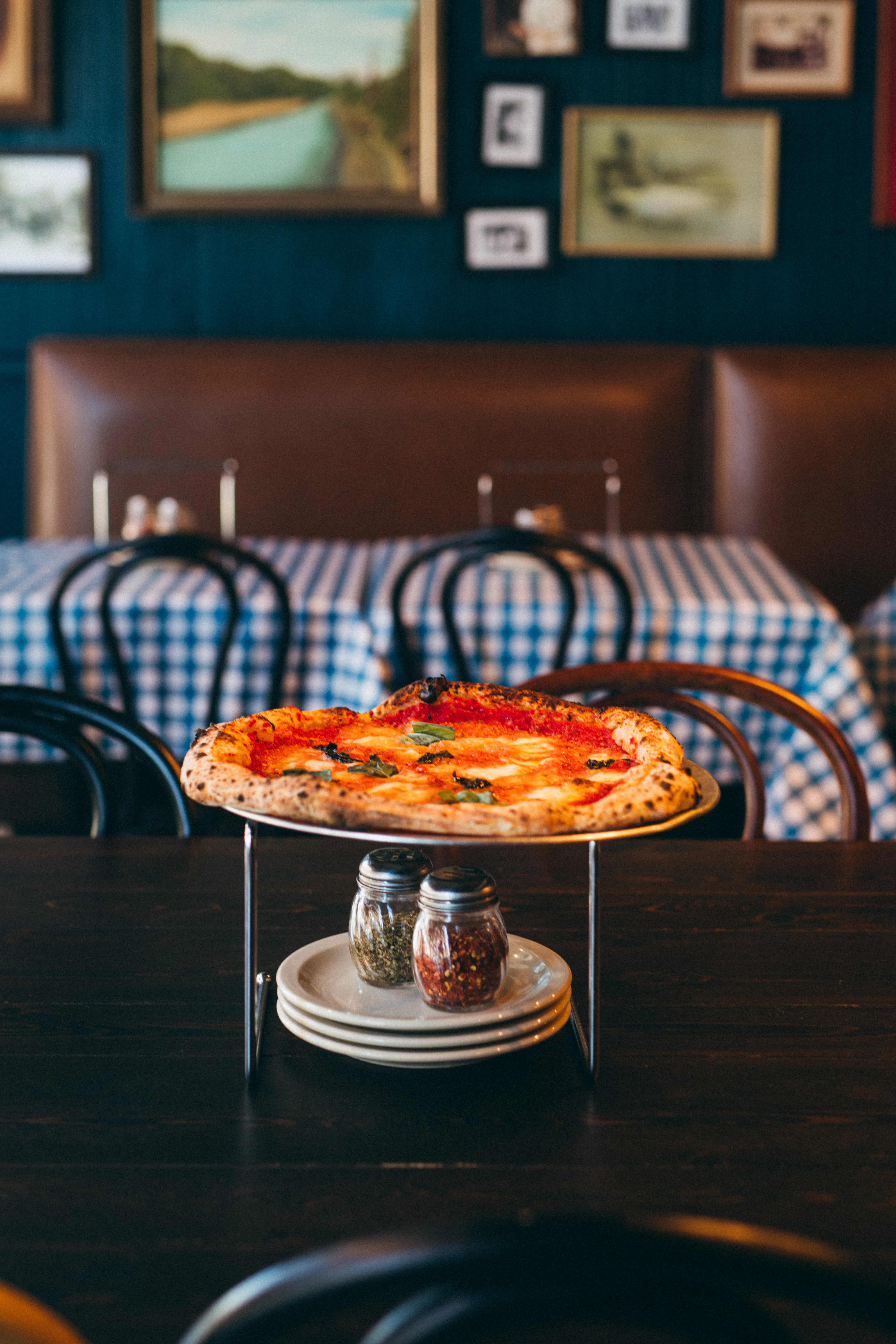 Margherita pizza on a stand in a cozy restaurant setting
