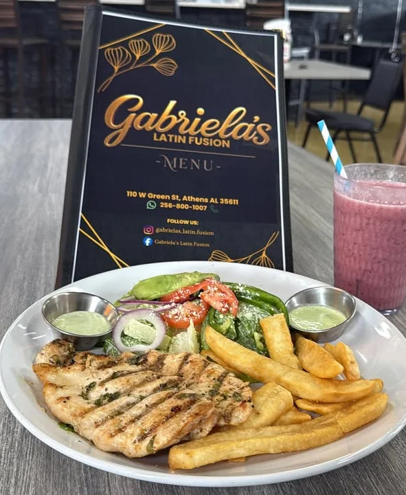 Grilled chicken with Latin salad and fries at a vibrant restaurant