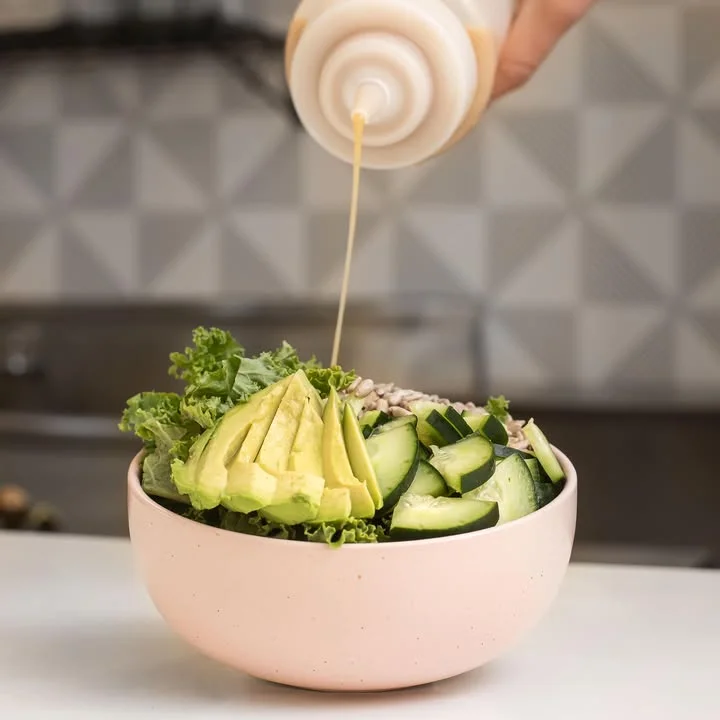Fresh salad bowl with avocado and dressing, showcasing healthy Mediterranean cuisine