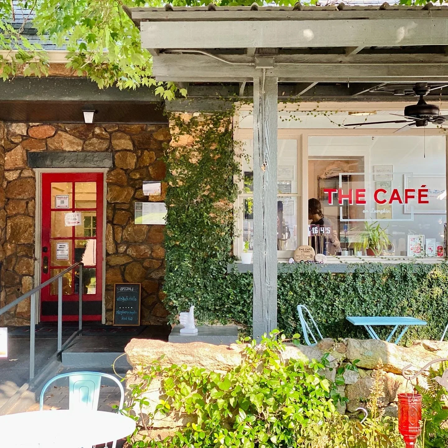 Charming café exterior with stone walls and greenery