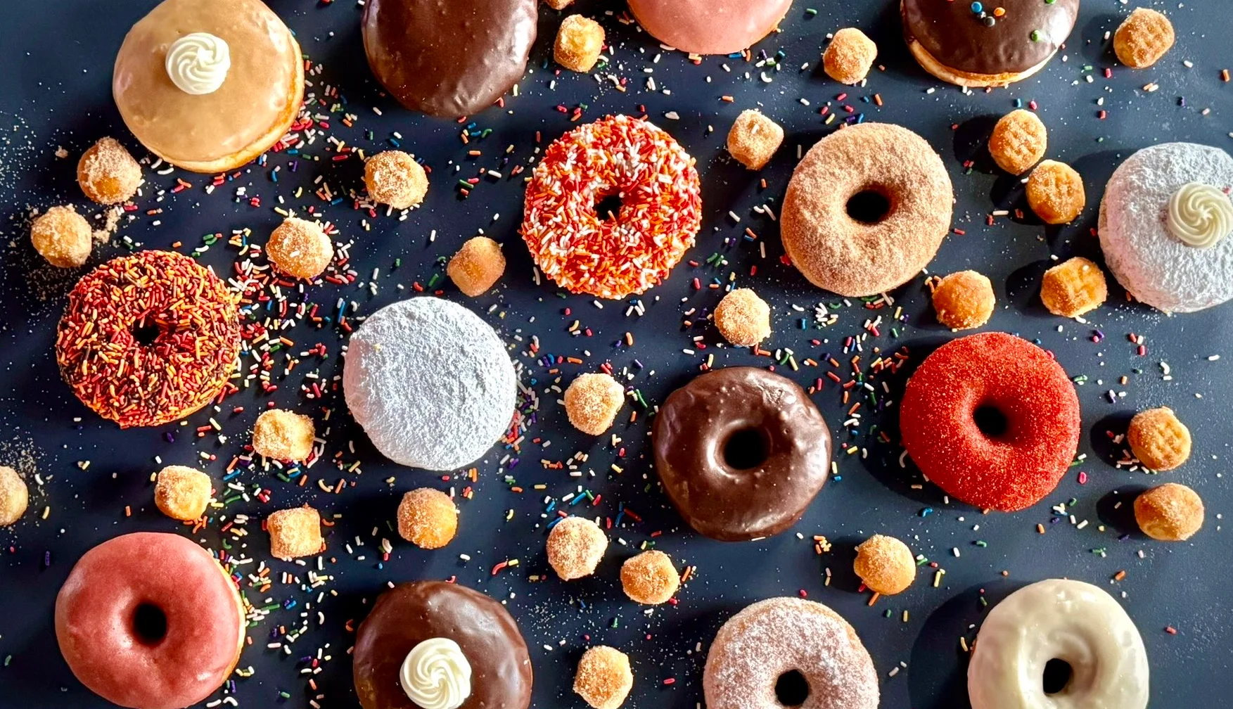 Colorful assortment of gourmet donuts with sprinkles and toppings