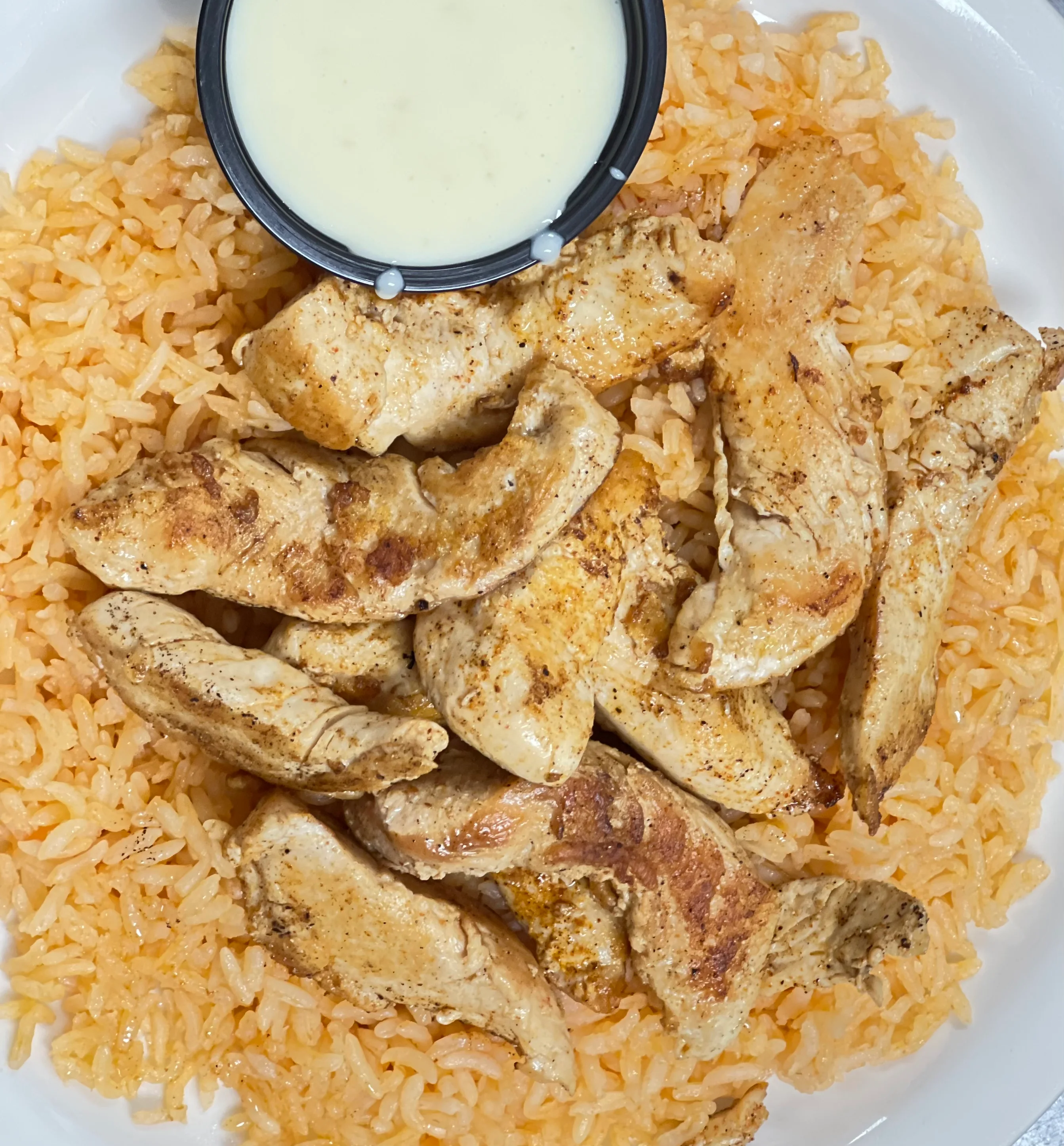 Grilled chicken over seasoned rice with dipping sauce