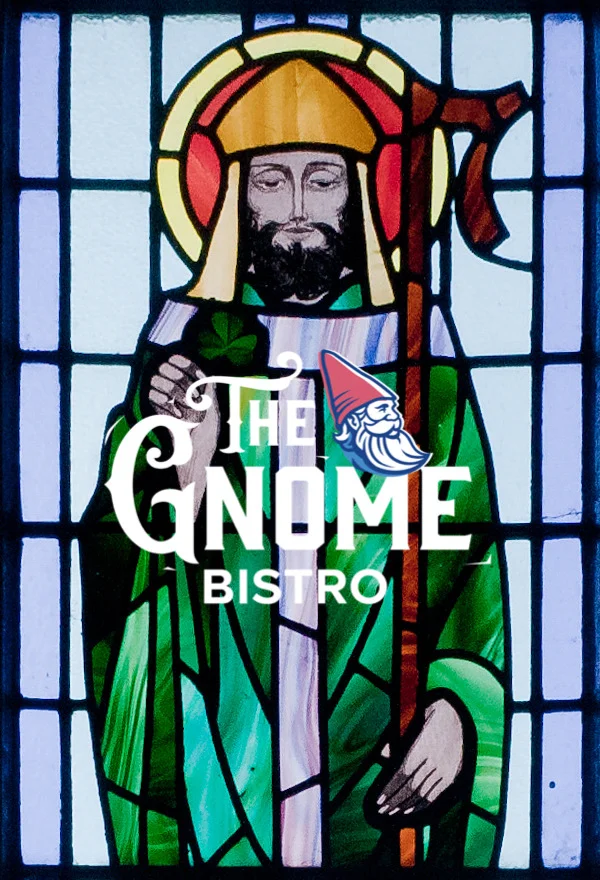 A stained glass window featuring a figure holding a staff, creatively overlaid with branding for a bistro.
