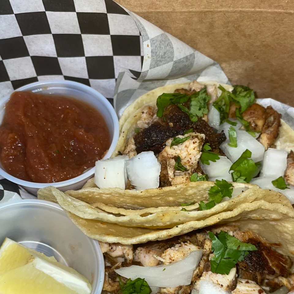 A picture of a beer and tacos.