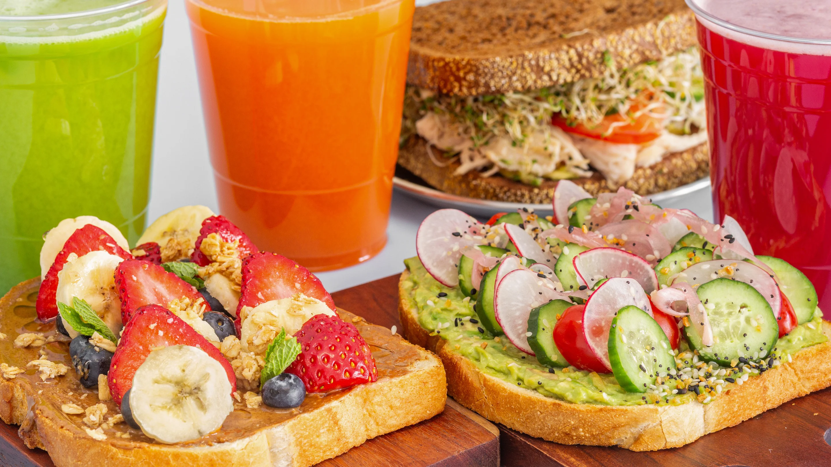 Colorful avocado toast and fruit toast with fresh juices