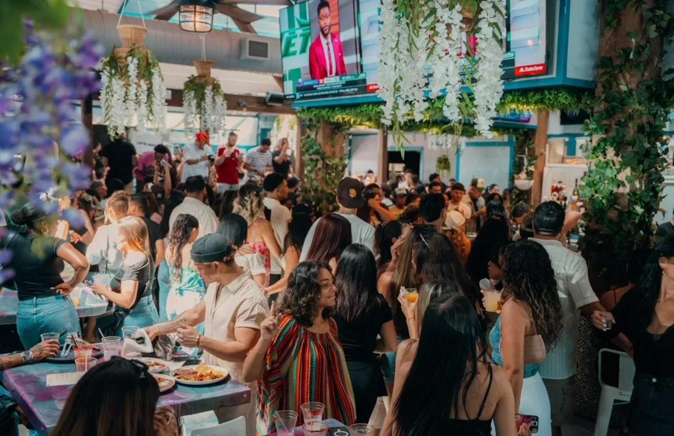 Vibrant restaurant scene with lively crowd and tropical decor
